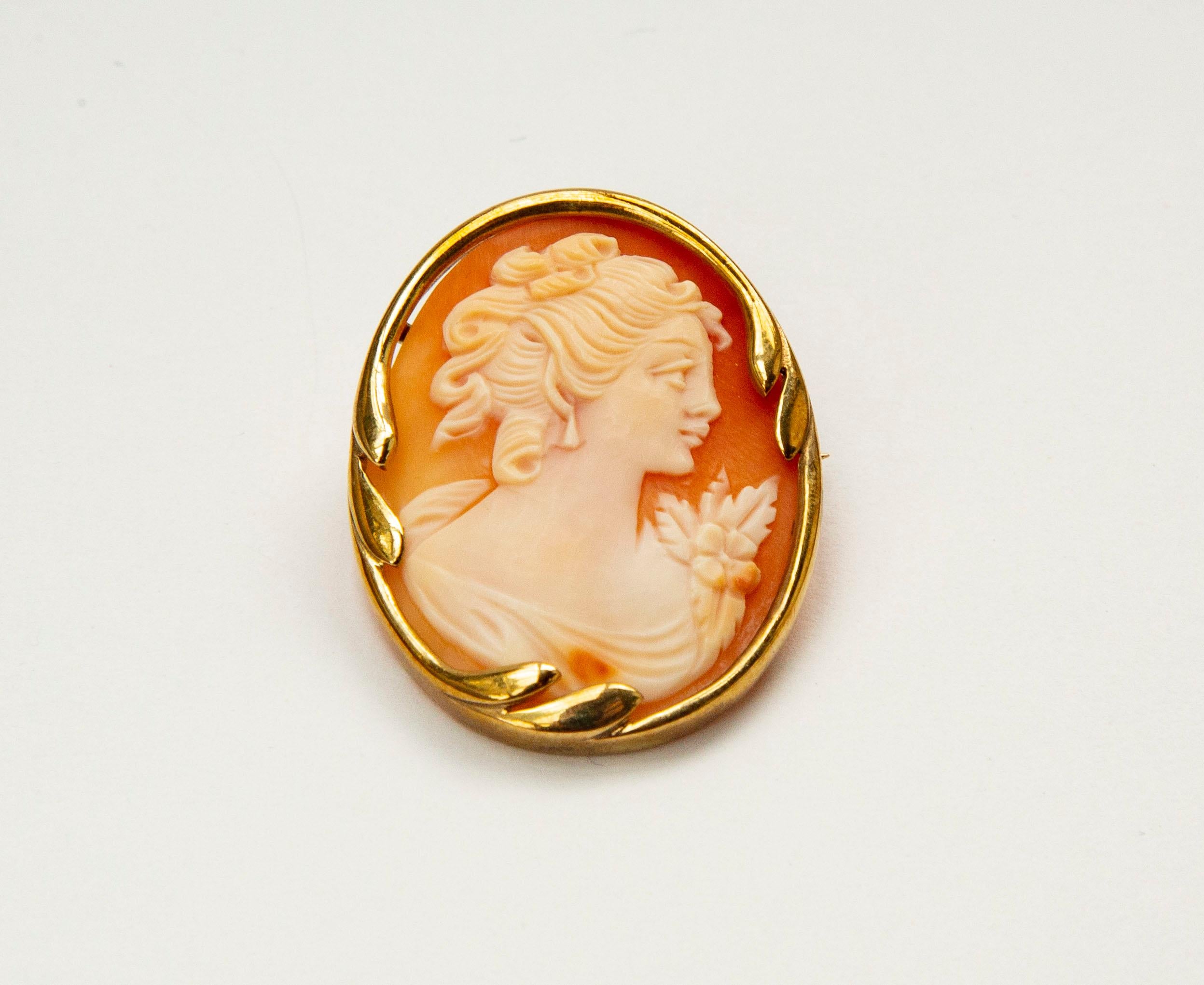 A vintage (ca. 1950s) brooch/pendant. The item is made of 8 karat yellow gold with a shell cameo featuring a finely carved female silhouette. The item is marked with 333 that stands for the 8 karat gold content and with the manufacturer's initials