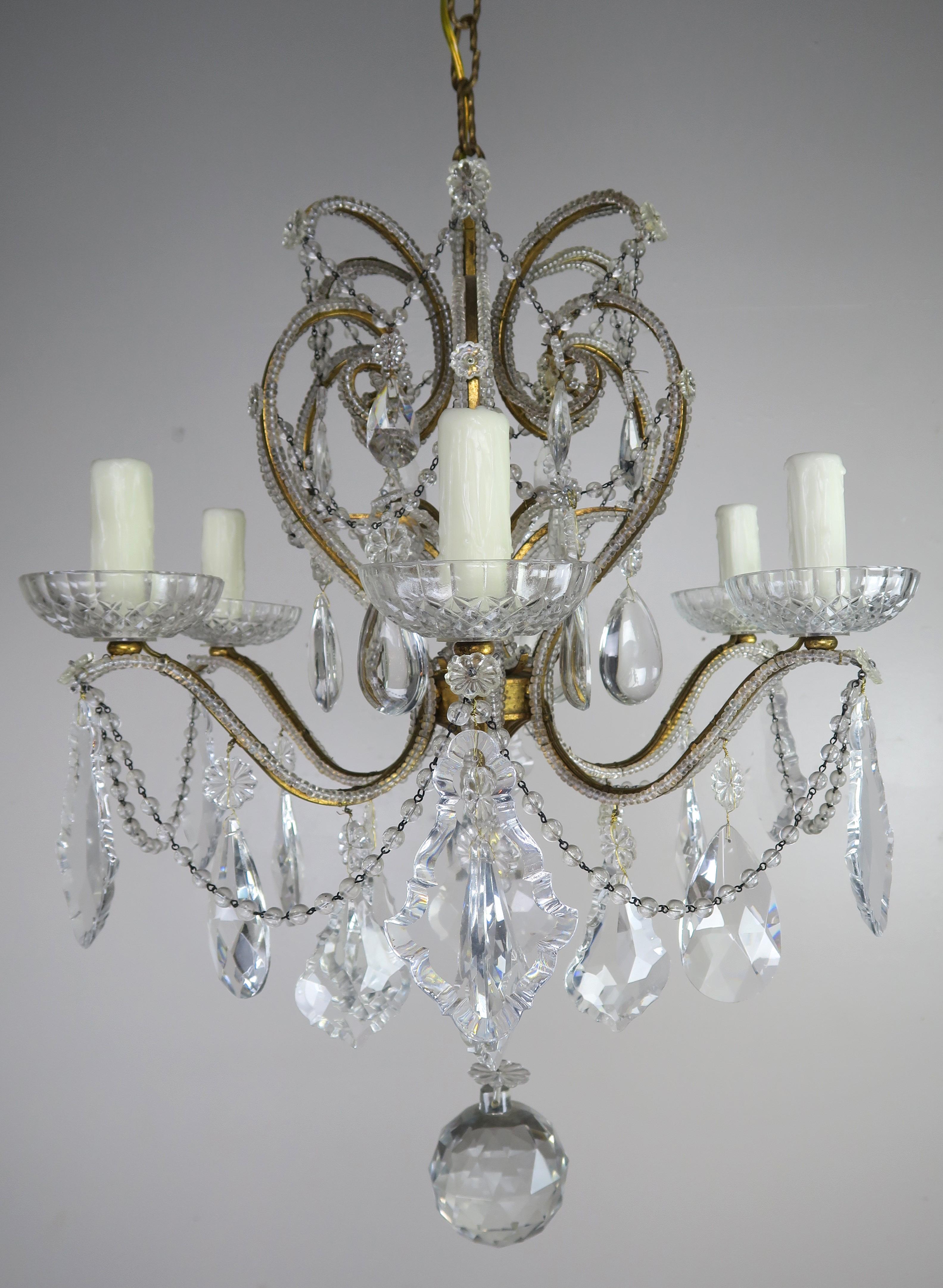 (8) light Italian crystal gilt brass chandelier. The light fixture is adorned with pendulum and almond shaped crystals with garlands of English cut beads throughout. There is a 4