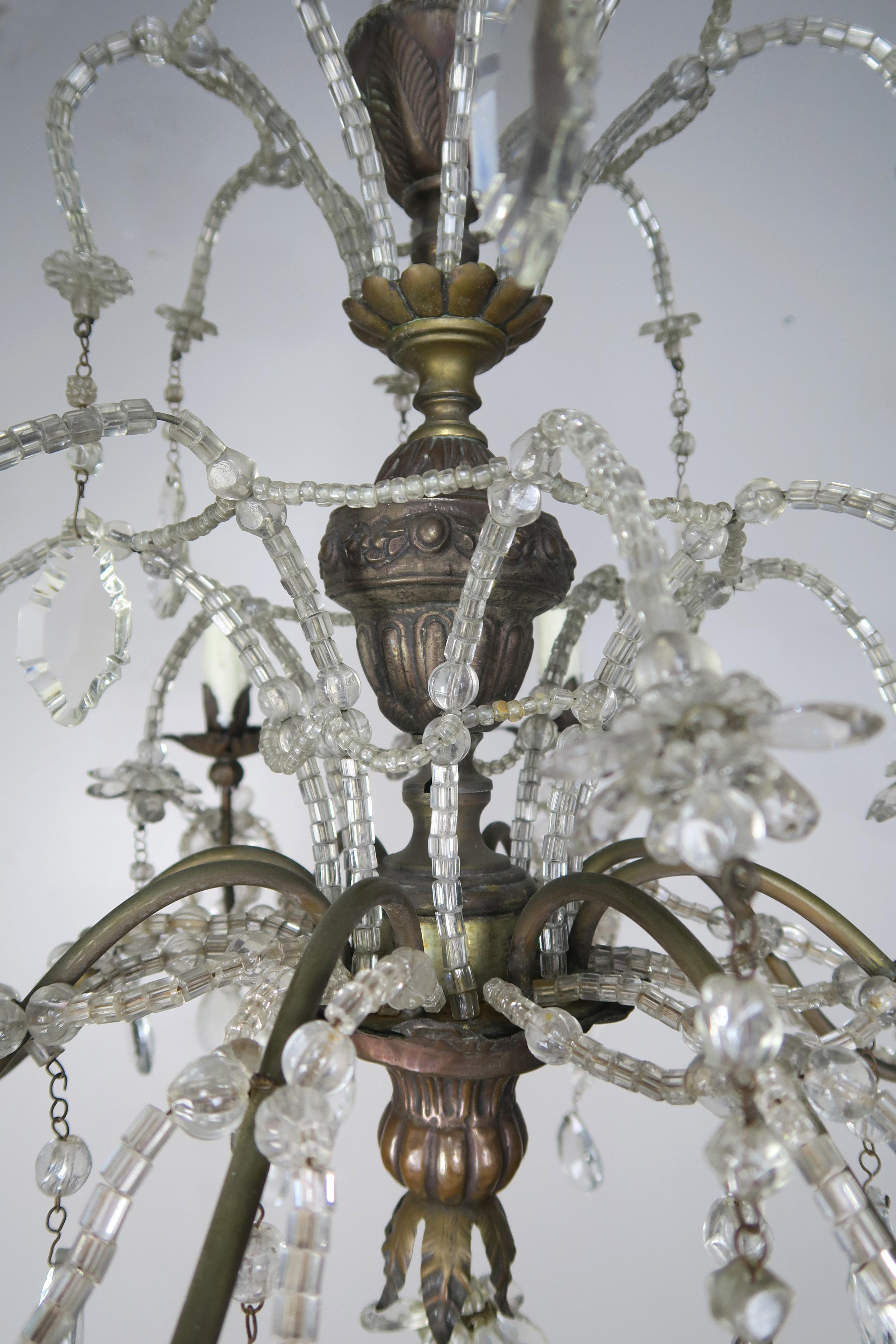 Eight-light Italian crystal brass waterfall style chandelier with crystal beads beautifully placed lightly throughout the chandelier with drop of beads forming intricate designs throughout the light fixture. The chandelier has been newly rewired