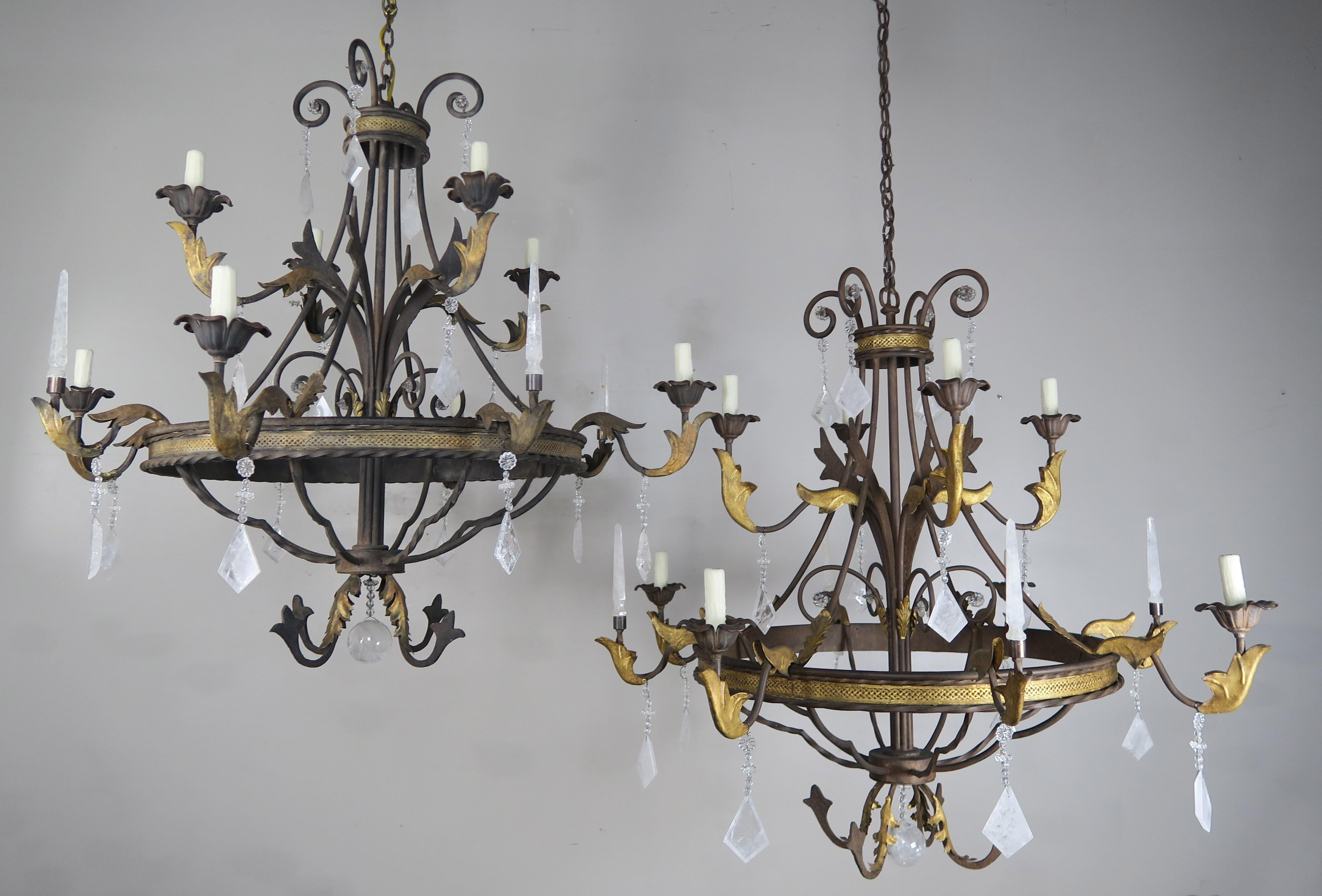 Pair of 8-light two-tier Spanish Baroque style rock crystal chandeliers with gold leaf highlights. Rock diamond shaped crystals and rock crystal spheres can be seen placed throughout the pair of chandeliers. The chandeliers are newly rewired with