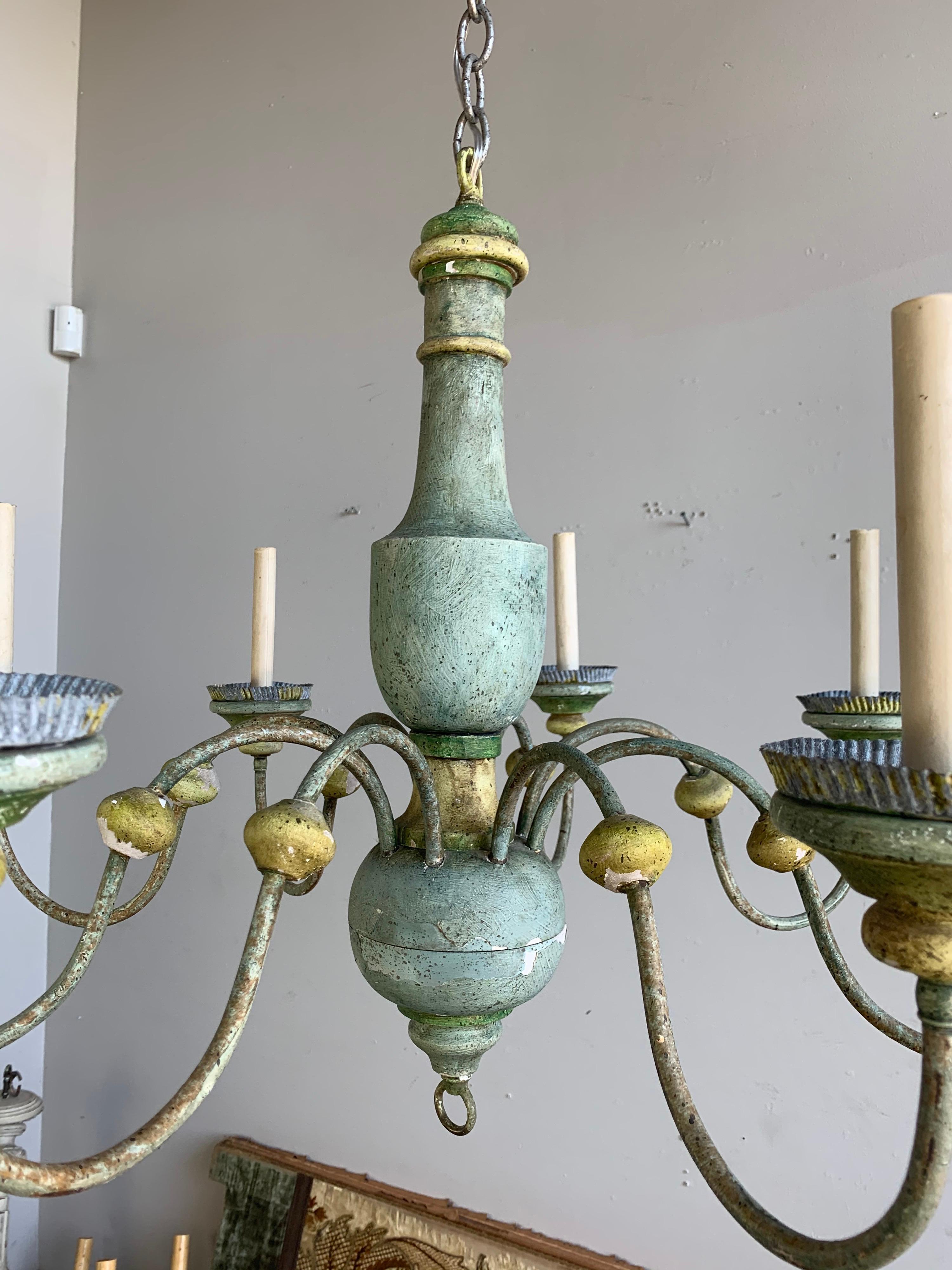 8-light Italian painted wood chandelier in soft shades of blue, green and gold. The are 8 iron arms that end in wood and metal bobeches. The fixture is wired and ready to install with chain and canopy included.