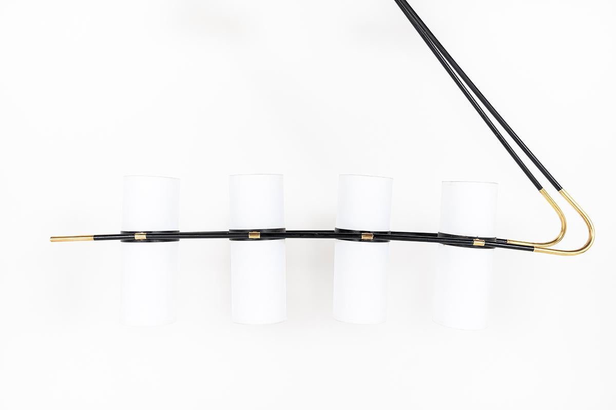 Pendant or wall light manufactured by the famous French Maison Lunel in 1950. 
Composed of solid brass base, black metal and brass arm, with 4 circles with 2 sockets light. In total 8 lights. 
8 bespoke lampshades in white paper.