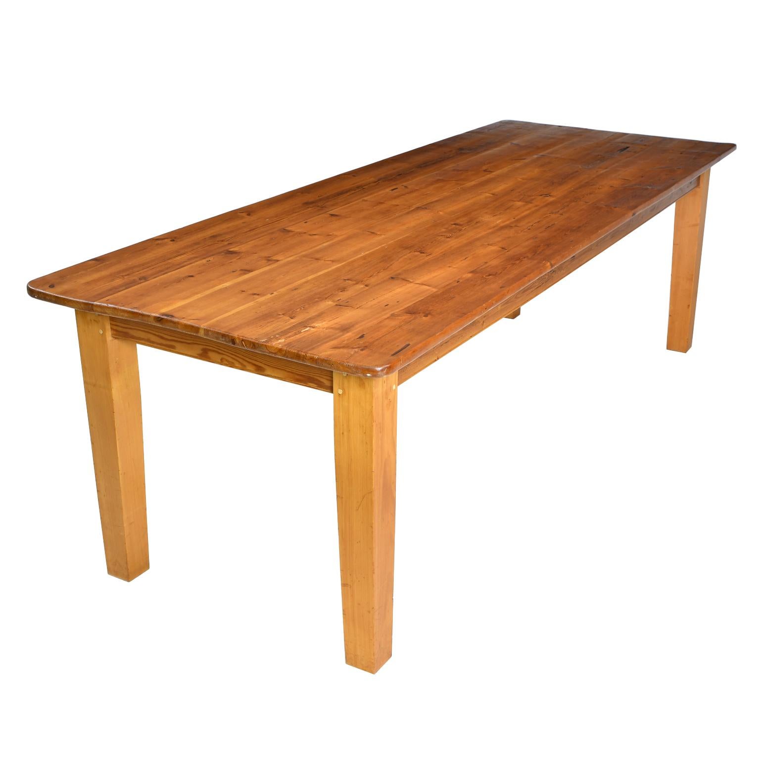 This 8' country pine dining table has a beautiful antique pine plank top over heavy tapered square legs that are made from old pine beams and are joined to the apron with mortise and Tenon construction, and then fastened with square pegs. Very