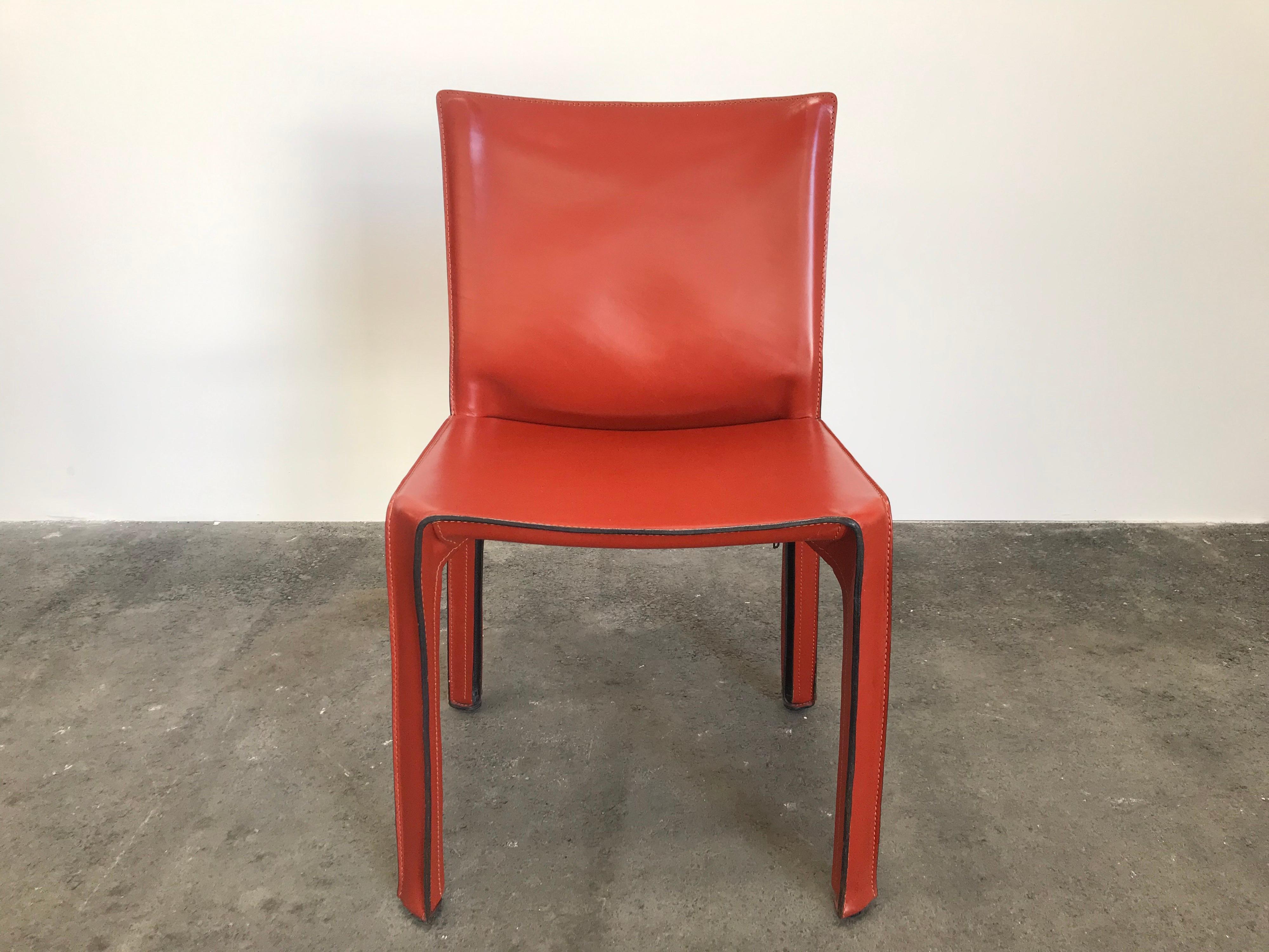 Set of 8 Mario Bellini CAB 412 chairs, made by Cassina in the 1980s. Flexible steel frame covered with a skin of high quality Russian Red (also known as Bulgarian Red) saddle leather. This elegant, versatile chair is equally suitable for the dining