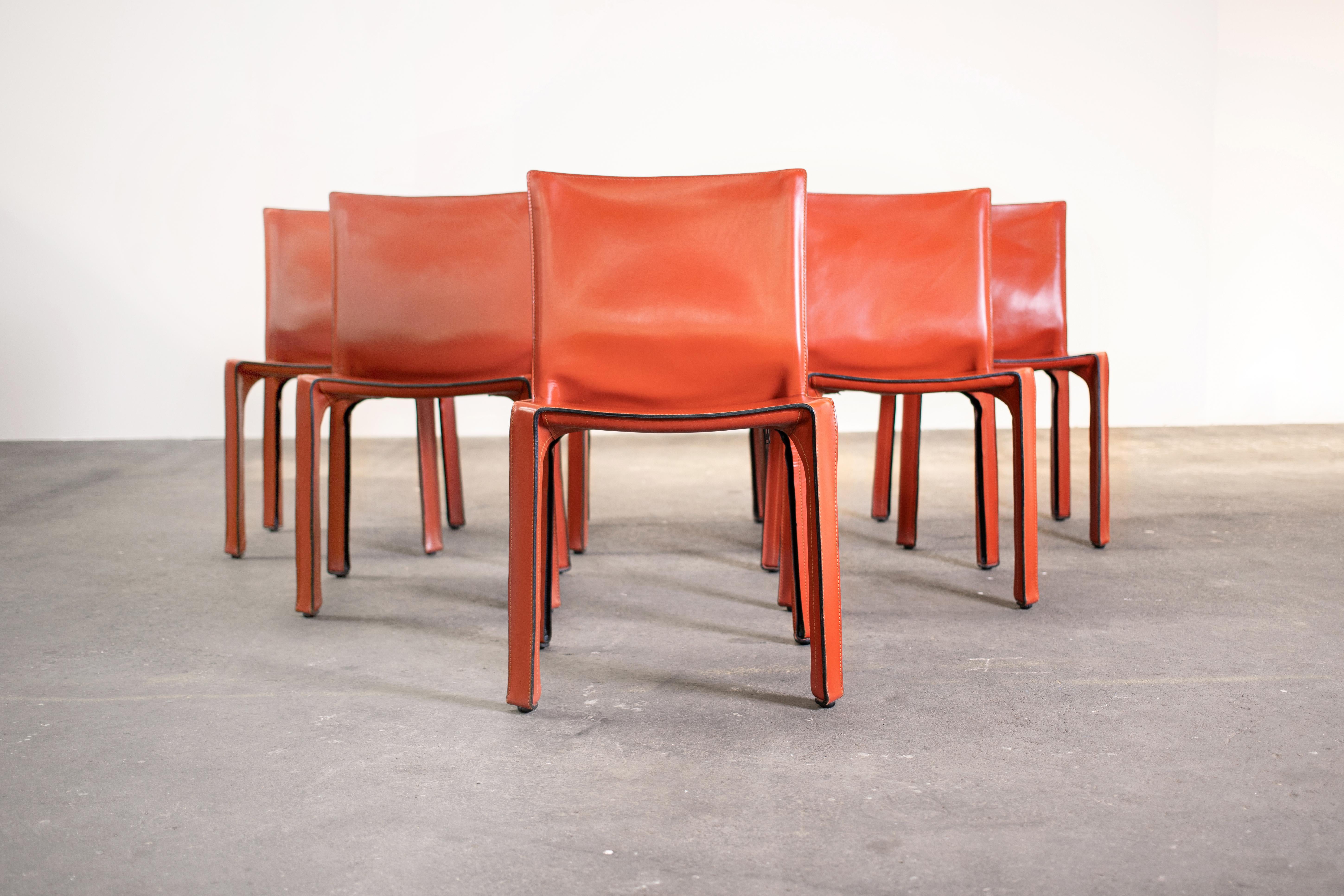 Set of 8 Mario Bellini CAB 412 chairs, made by Cassina in the 1980s. Flexible steel frame covered with a skin of high quality Russian Red (also known as Bulgarian Red) saddle leather. This elegant, versatile chair is equally suitable for the dining