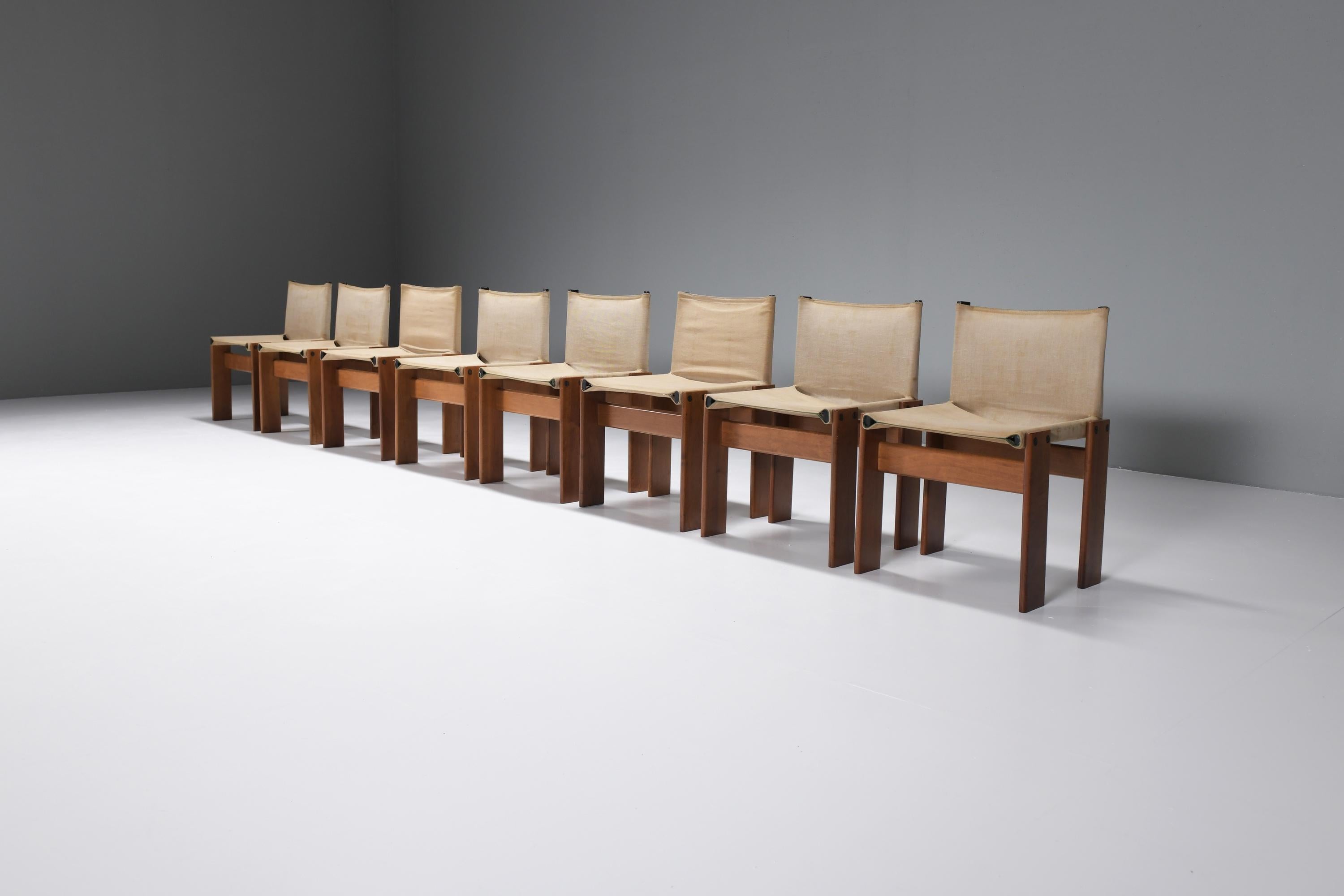 Matching set of 8 Monk dining chairs with a striking combination of the original canvas and warm tone walnut.  
Designed by Afra & Tobia Scarpa for Molteni Italy, 1974.

The particular feature of this model is the support structure composed of two