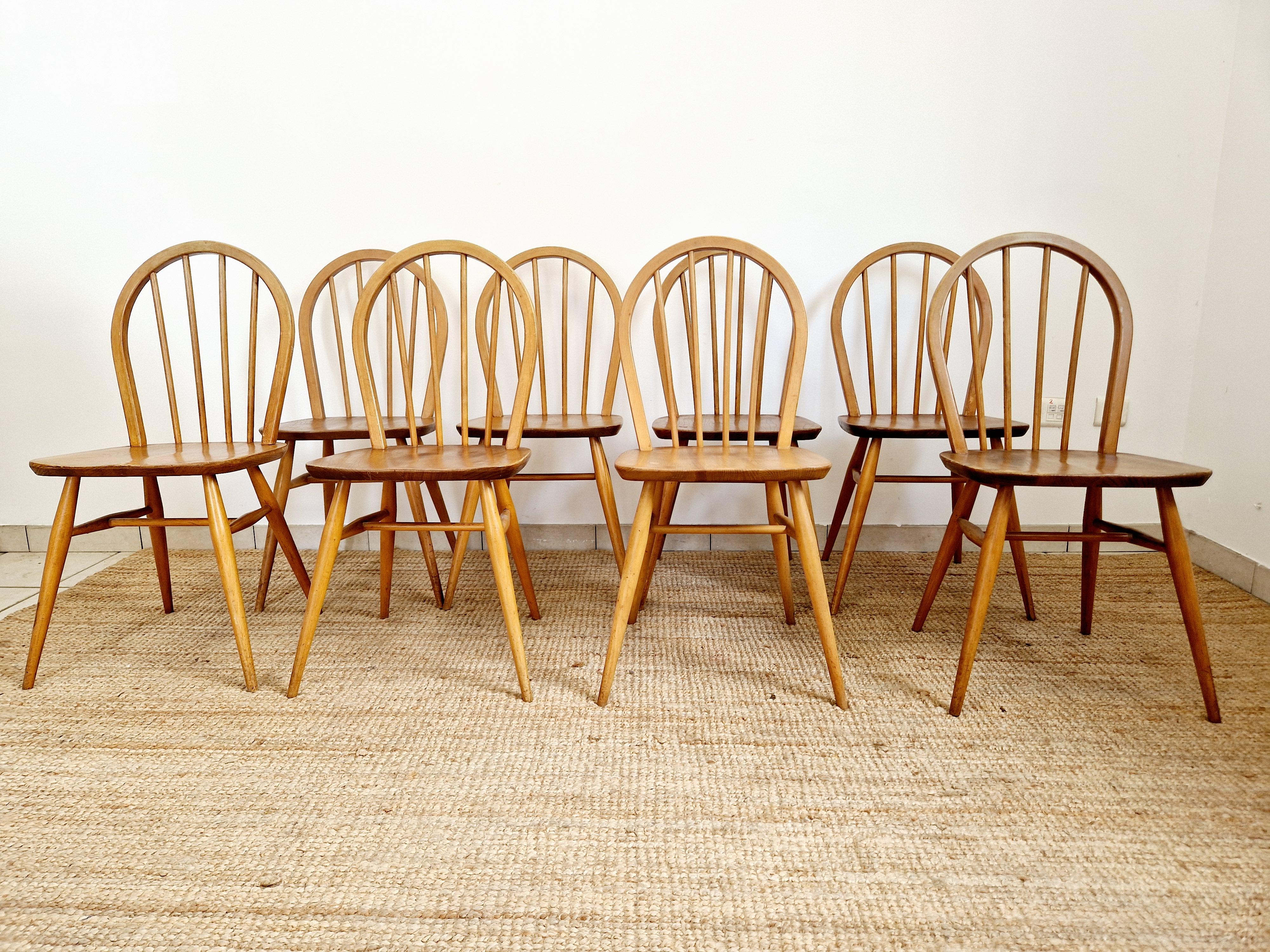 Queste 8 sedie da pranzo Windsor di Ercol in olmo e faggio sono uno splendido esempio di modernismo di metà secolo, realizzate negli anni '60 nel Regno Unito. Realizzate a mano in olmo biondo e faggio massiccio con finitura cerata, queste sedie di