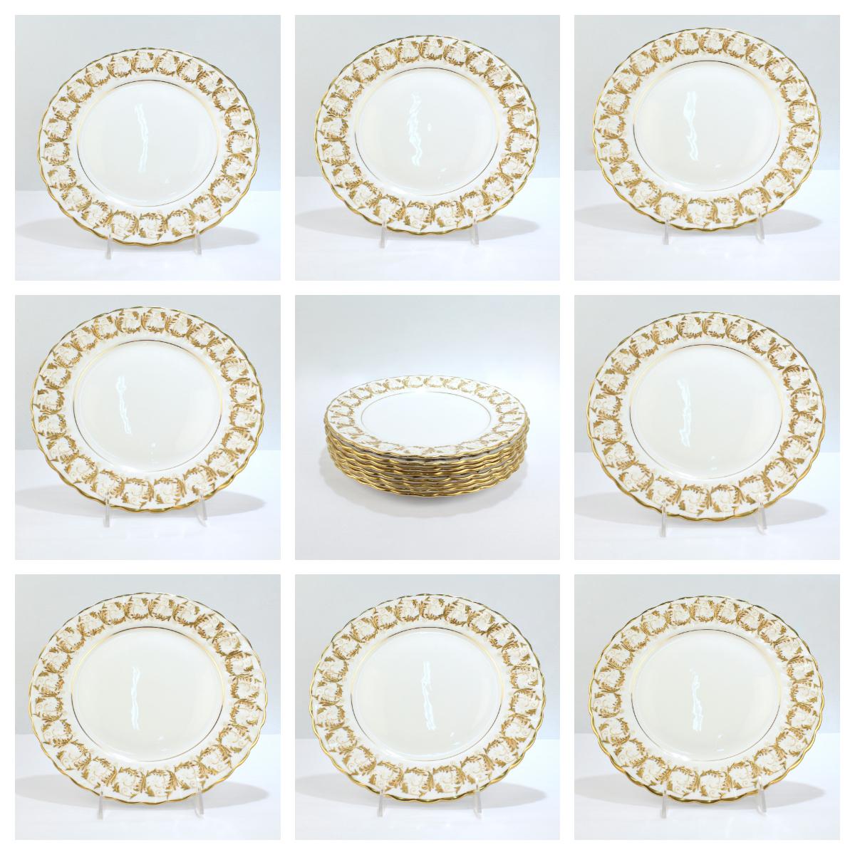 A fine set of 8 bone china dinner plates by Gladstone.

With a scalloped border and 2 tone raised gold decoration to the borders. 

A thin gilt line outlines the interior of the plate.

Simply a lovely set that is perfect for a table of