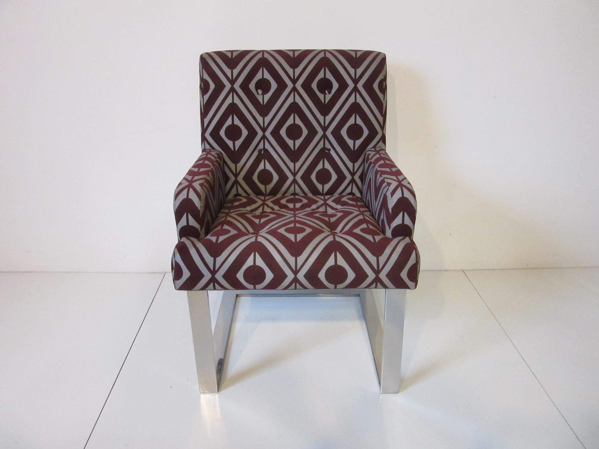 A set of eight cantilevered polished aluminum based dining chairs with two arm and six side chairs upholstered in the original burgundy colored ultra suede fabric with printed silver toned mod designs . Manufactured by the Directional Furniture