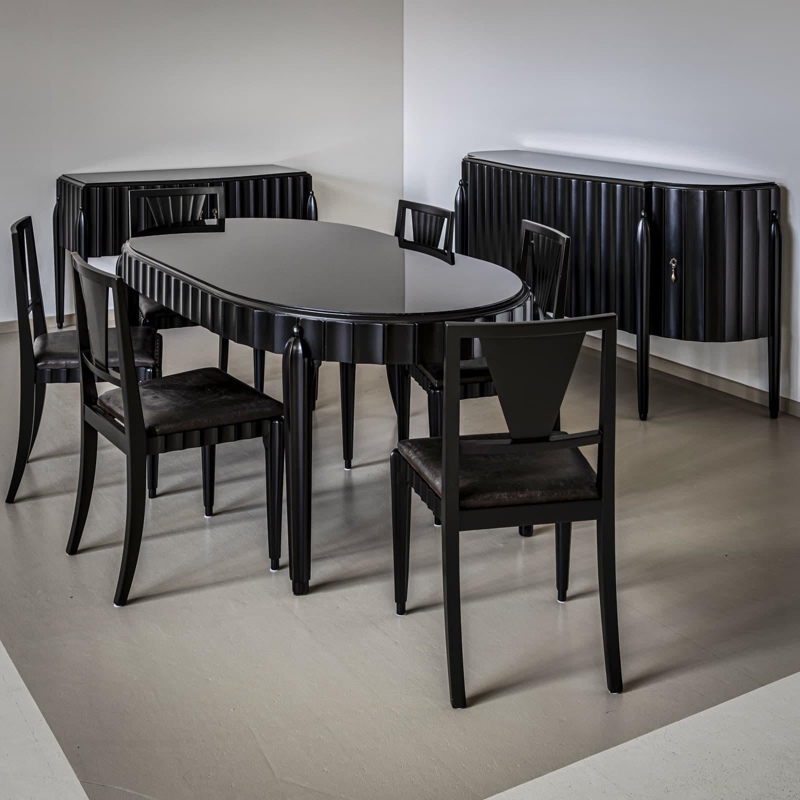 Salle à manger Art Déco composée d'un grand buffet, d'une table à manger et de six chaises d'appoint. Les meubles sont ébonisés. Les cannelures décoratives sur les cadres et la façade du buffet unifient l'ensemble. Les chaises sont recouvertes de