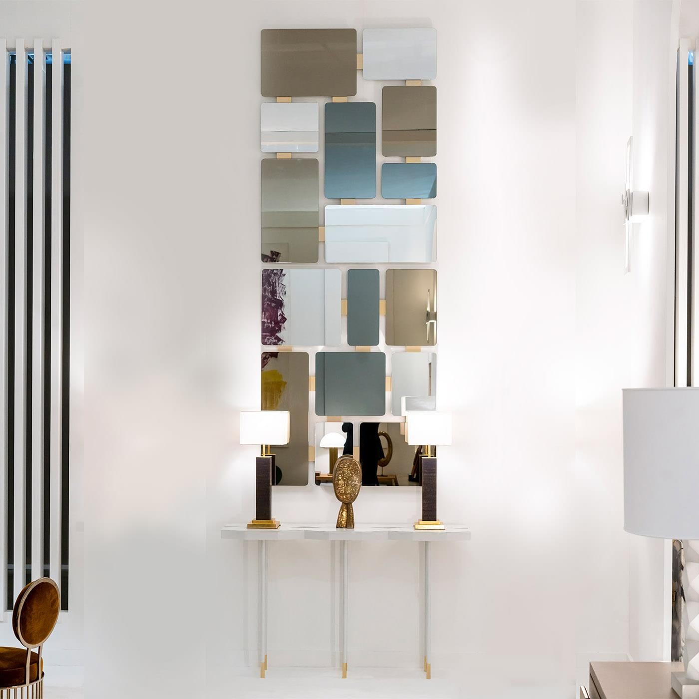 A stunning sculptural design, this iconic mirror is composed of eight mirrors displaying different shapes and sizes, as well as finishes. Mounted on a matte white-lacquered wooden base, each mirror is connected with 18K gold-plated brass inserts.
