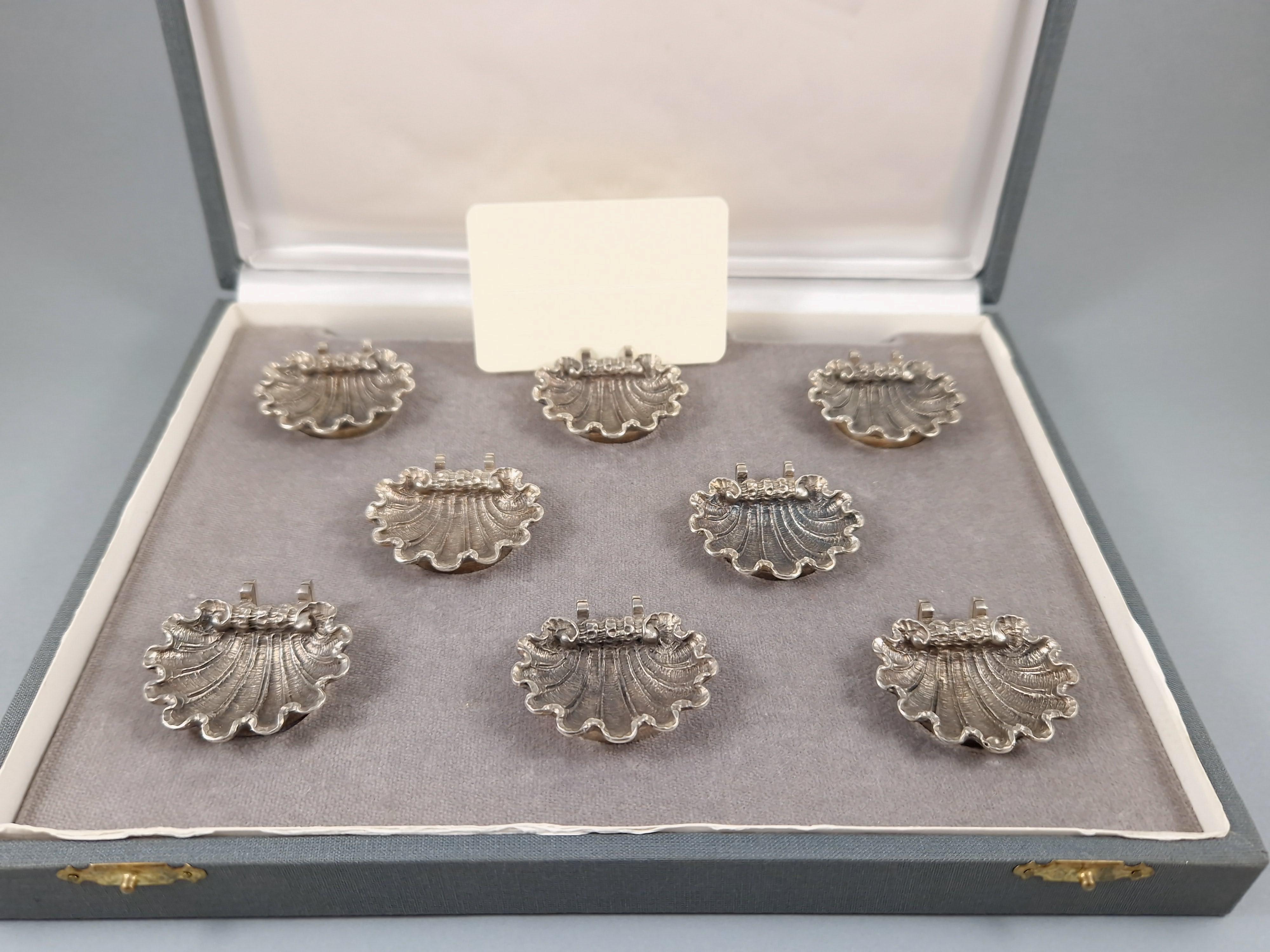 Pretty set of 8 place card holders / salt cellars in solid silver 
In the shape of a finely chiseled shell 

800 silver hallmark 
Length: 4.1 cm 
Width: 3.8 cm 
Height: 1 cm 
Weight: 181 grams 

In its original case.