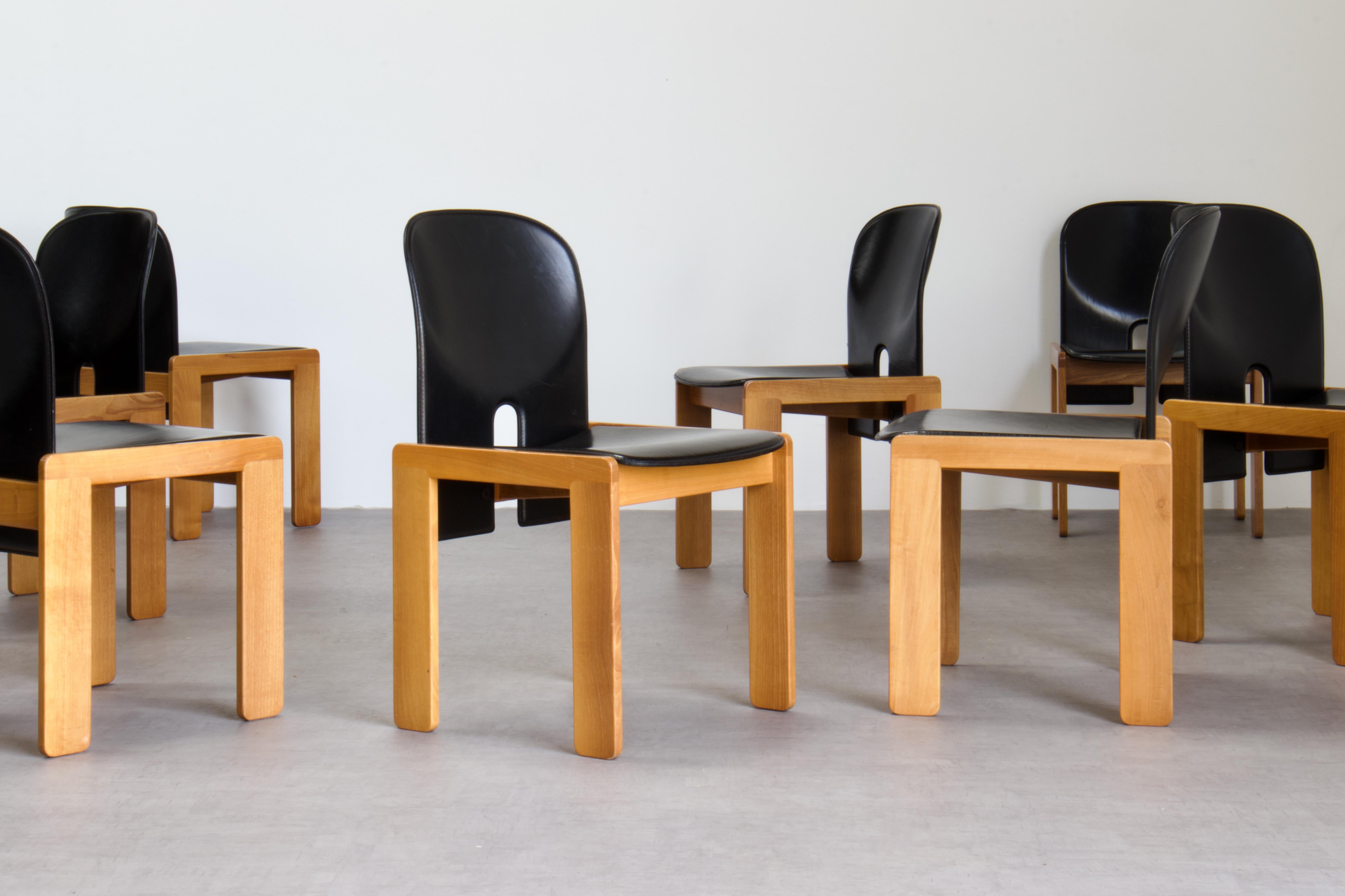 Set of eight Model 121 dining chairs, designed by Afra and Tobia Scarpa and produced by the Italian manufacturer Cassina in 1967. They feature black saddle leather upholstery and a lacquered pale wood structure (ash). 

Remarkable condition for the