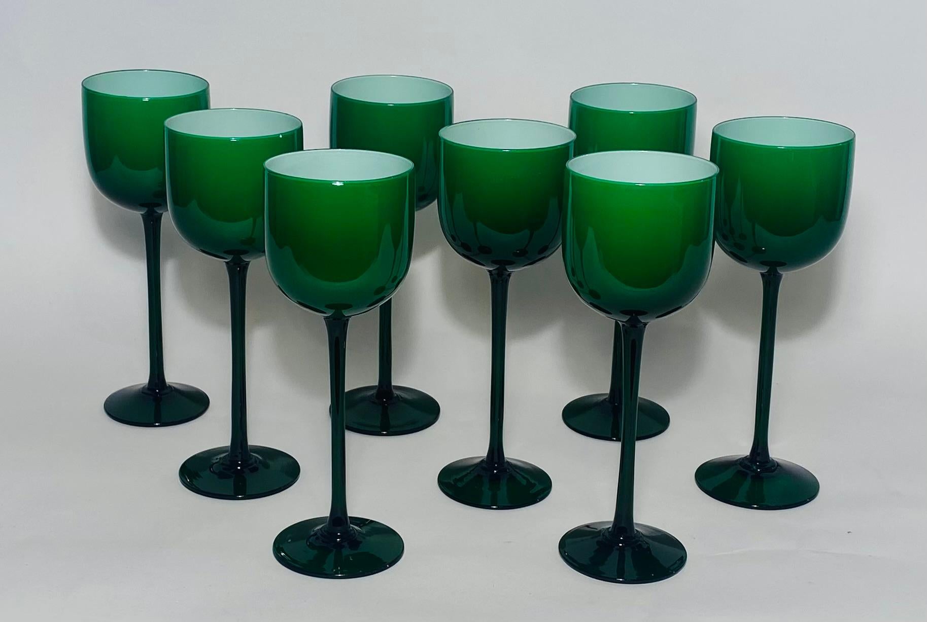 A striking set of vibrant green and white cased goblets measuring a generous nine and one half inches tall. Popular in the 1960's and ready to mix and match in with today's tables. The color is rich and dark green and also features an elegant stem