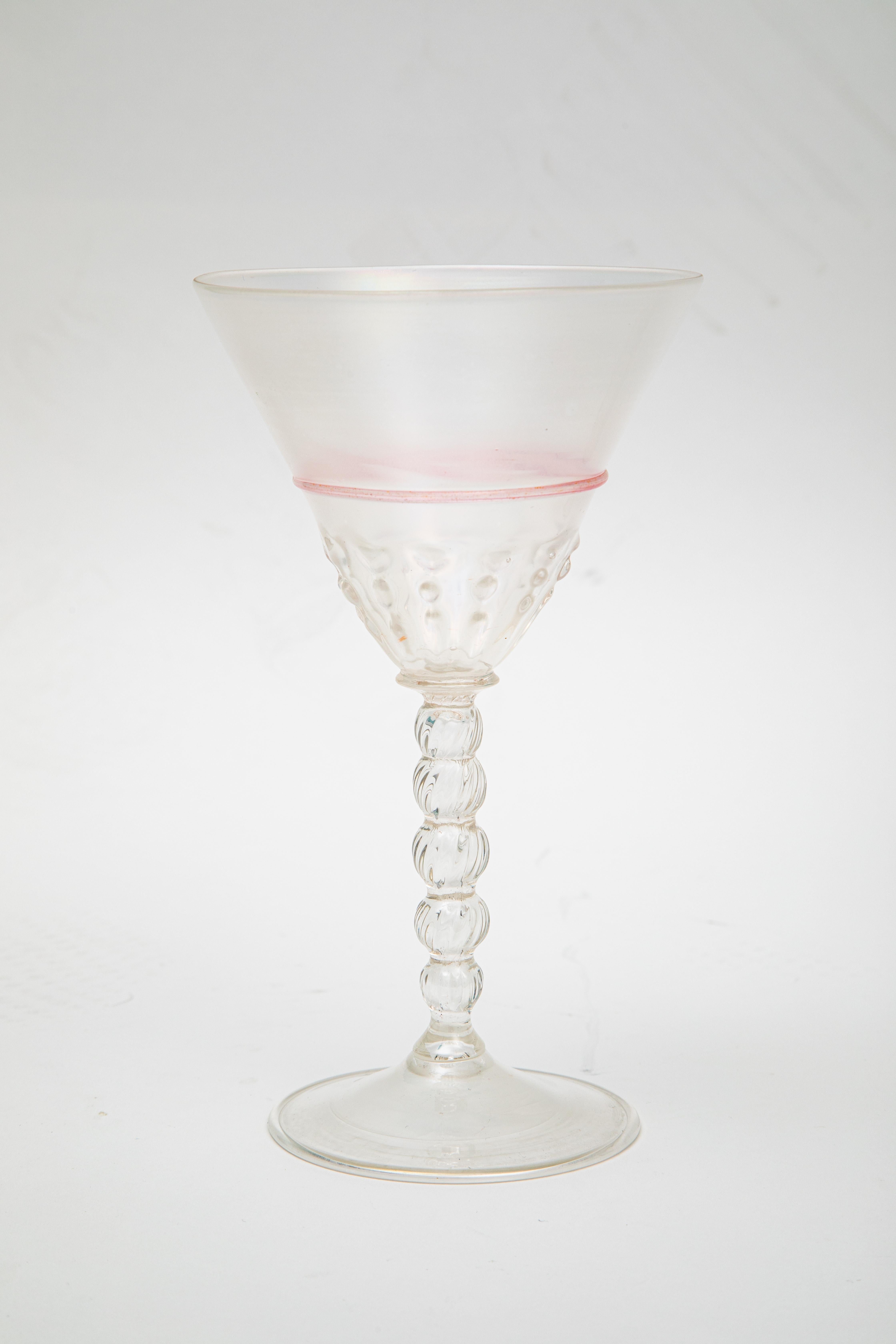 Un élégant ensemble de 8 gobelets vénitiens soufflés à la bouche provenant de l'île de Murano en Italie. Cet ensemble se caractérise par un pied au design créatif, un bol de belle taille, une bande rose supplémentaire entourant le verre et une