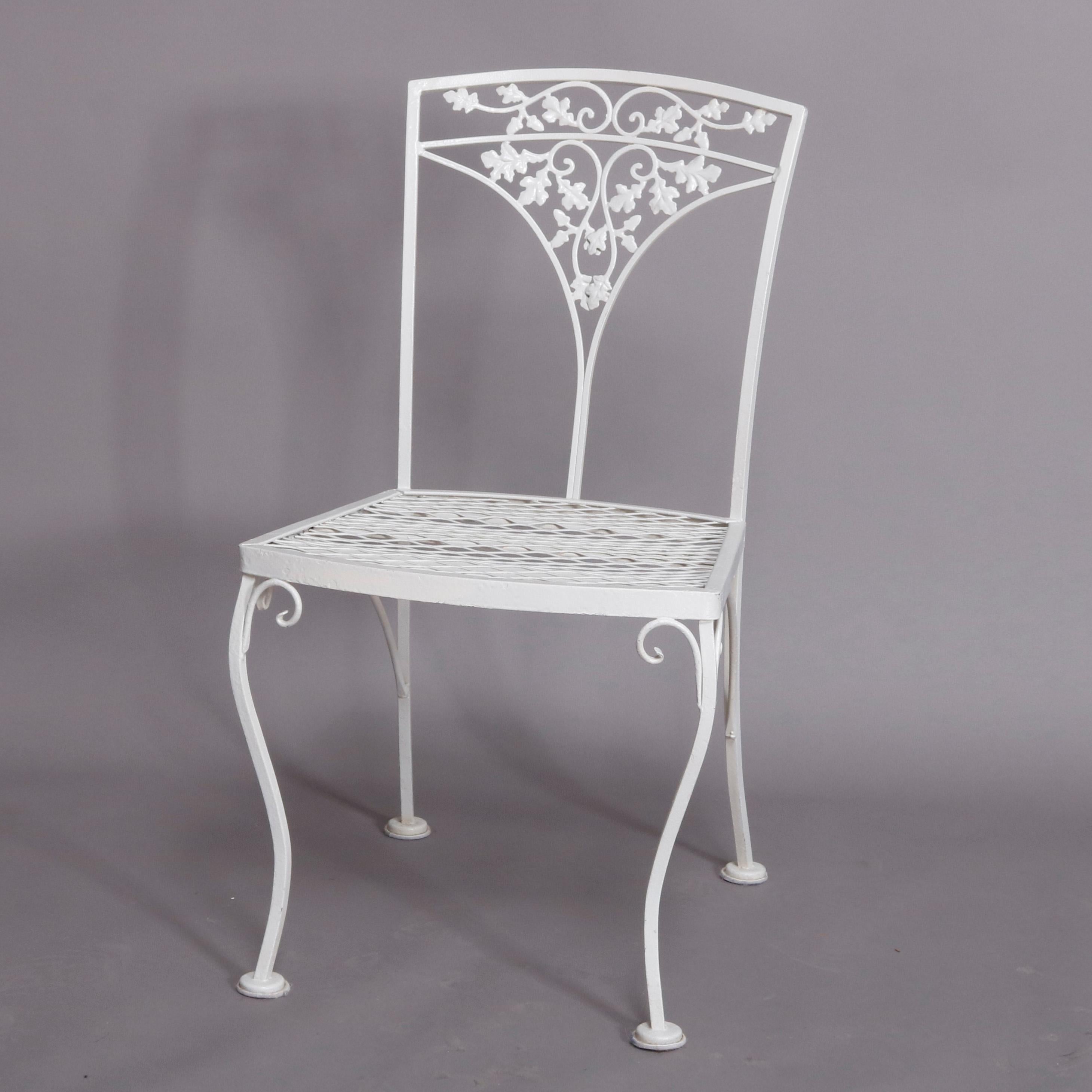 A set of 8 vintage Victorian style garden patio chairs each offer white painted wrought iron construction with open back having foliate and vine form splat over mesh seat and raised on cabriole legs with scroll corbels, 20th century

Measures: 33
