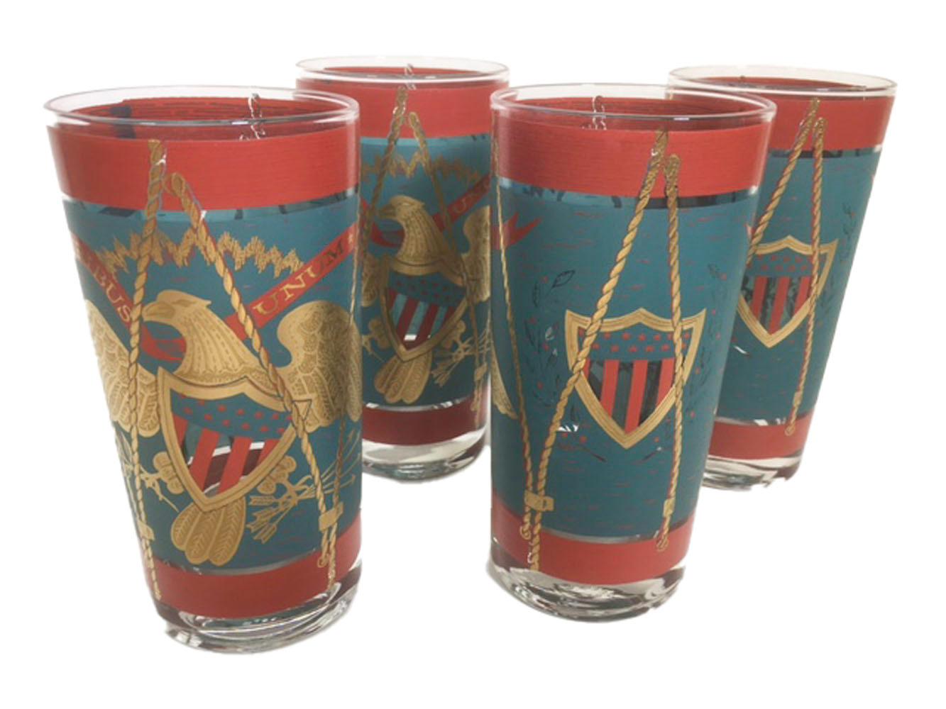 Mid-Century Modern highball glasses decorated as parade drums in teal and red enamel with 22 karat gold.
The front with a large patriotic eagle below a banner with the motto E Pluribus Unum. The eagle with a stars and stripes shield on its breast