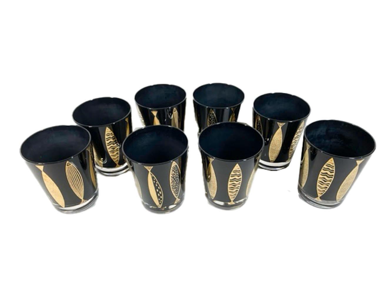 Set of eight Fred Press double old fashioned glasses with stylized fish in gold on clear glass with black frosted Interior.