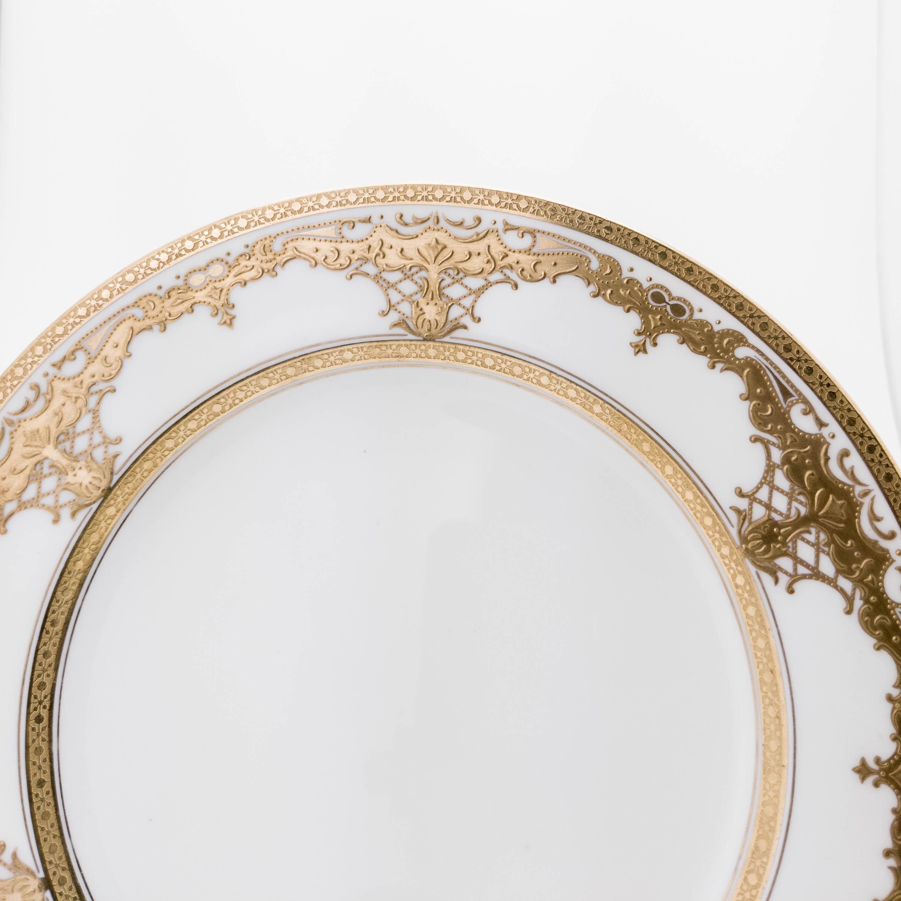 A Classic and elegant white and gold first course, dessert or salad plate by one of England's storied porcelain firms, Coalport England. This plate features a raised gilt encrusted foliate design on it's collar and crisp white porcelain ground.