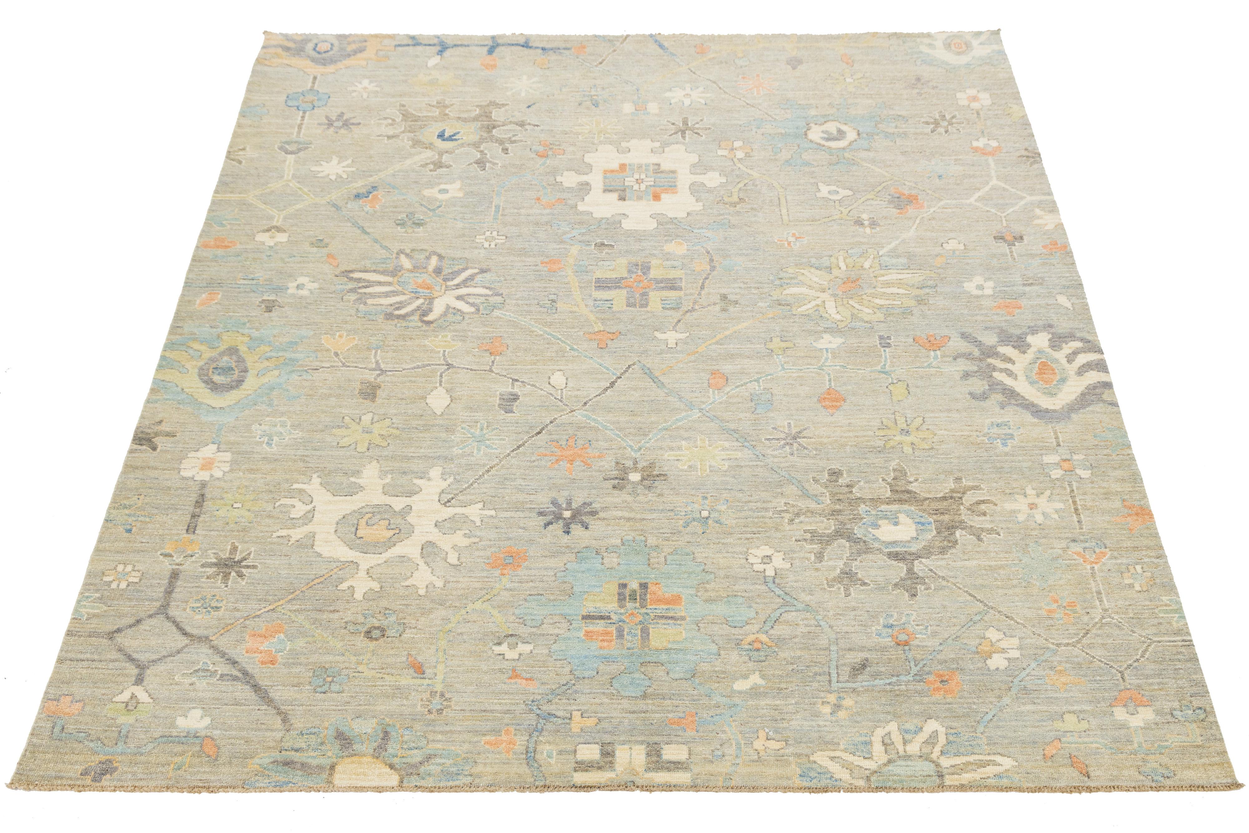 Hand-knotted modern Oushak style wool rug featuring a serene palette of beige, blue, and terracotta. Inspired by traditional Turkish designs, its stylized floral and geometric motifs offer timeless elegance with a contemporary twist. Ideal for
