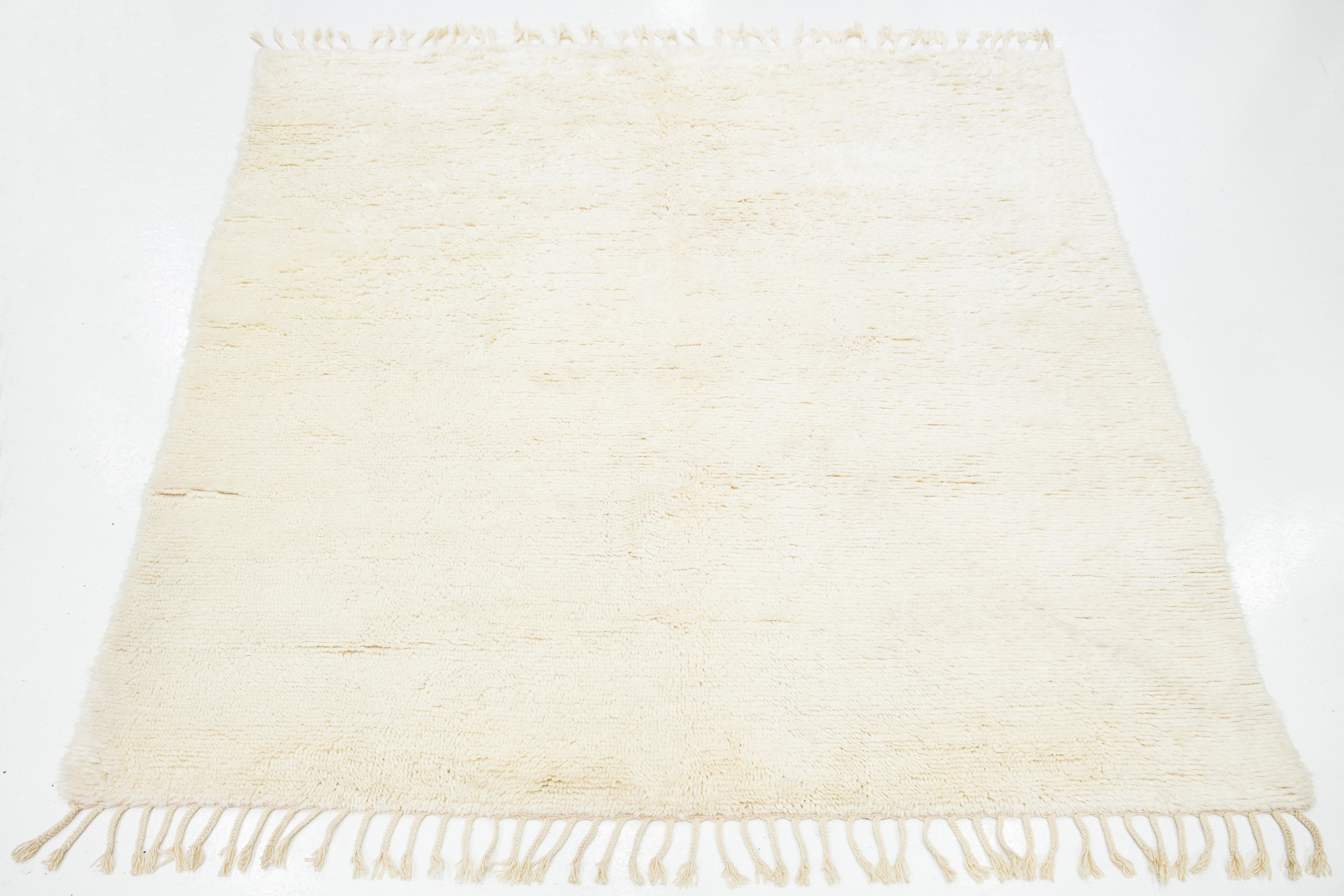 Preciosa alfombra contemporánea de lana anudada a mano de estilo marroquí. Esta alfombra Shag tiene un campo y flecos de color beige en un precioso diseño shag.

Esta alfombra mide 8'2