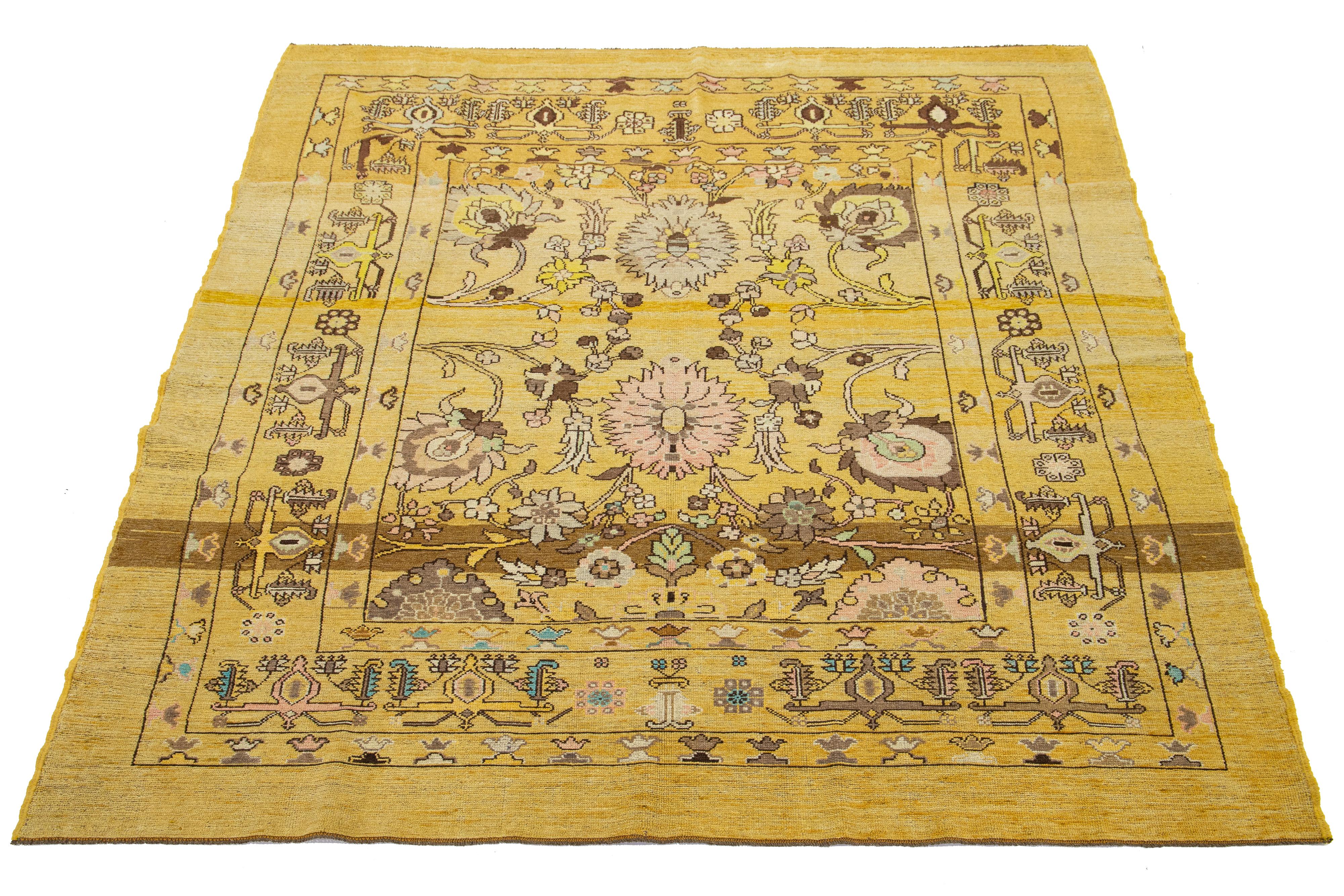 Ce magnifique tapis moderne en laine nouée à la main en format room-size présente un champ de verges d'or. Ce tapis de la Collection S/One met en valeur un étonnant motif floral botanique aux accents verts, pêches, bruns et beiges.

Ce tapis mesure