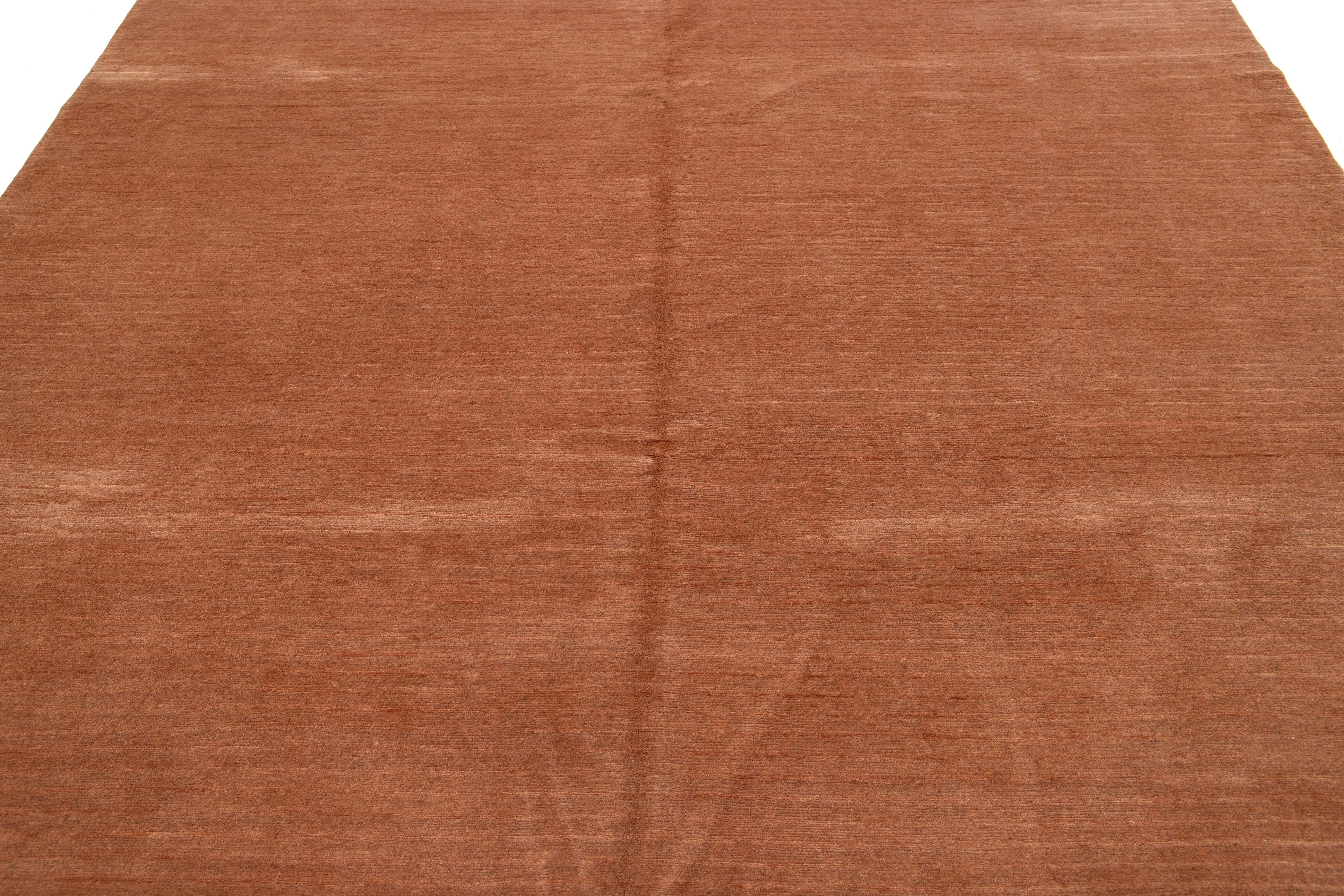 Ce tapis tibétain contemporain présente un motif rayé captivant qui attire l'attention. Fabriqué en laine ou en soie tibétaine de première qualité, il présente des détails complexes et met en valeur un riche champ cuivré pâle.

Ce tapis mesure 8'1''