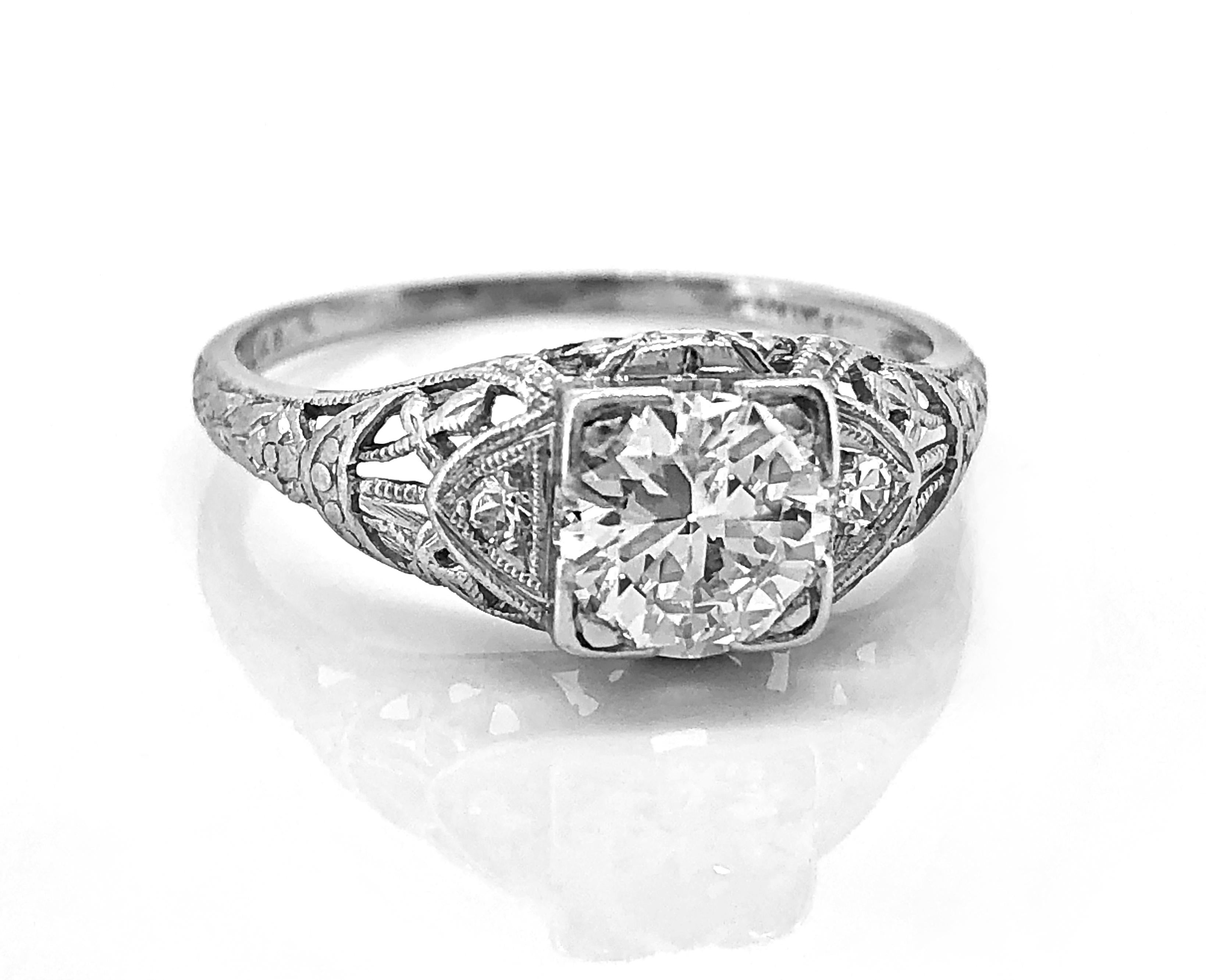A beautiful diamond Art Deco antique engagement ring with a scintillating .80ct. apx. diamond with VS1 clarity and G color. This elegantly crafted platinum ring is magnificently milgrained, filigreed and engraved. It is accented by .04ct. apx. T.W.