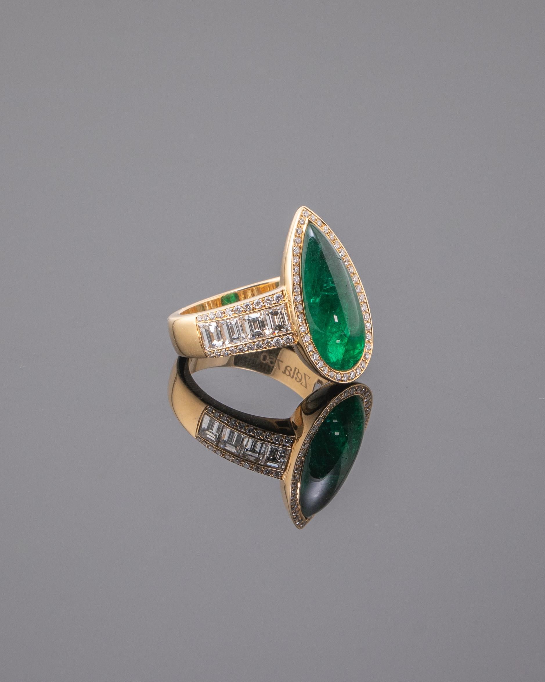 Perfectly designed cocktail ring with a gorgeous pear shape cabochon Zambian Emerald center stone. The stone has great luster and color with very few naturally occurring inclusions with colorless, VVS quality Emerald cut and Round diamonds on the