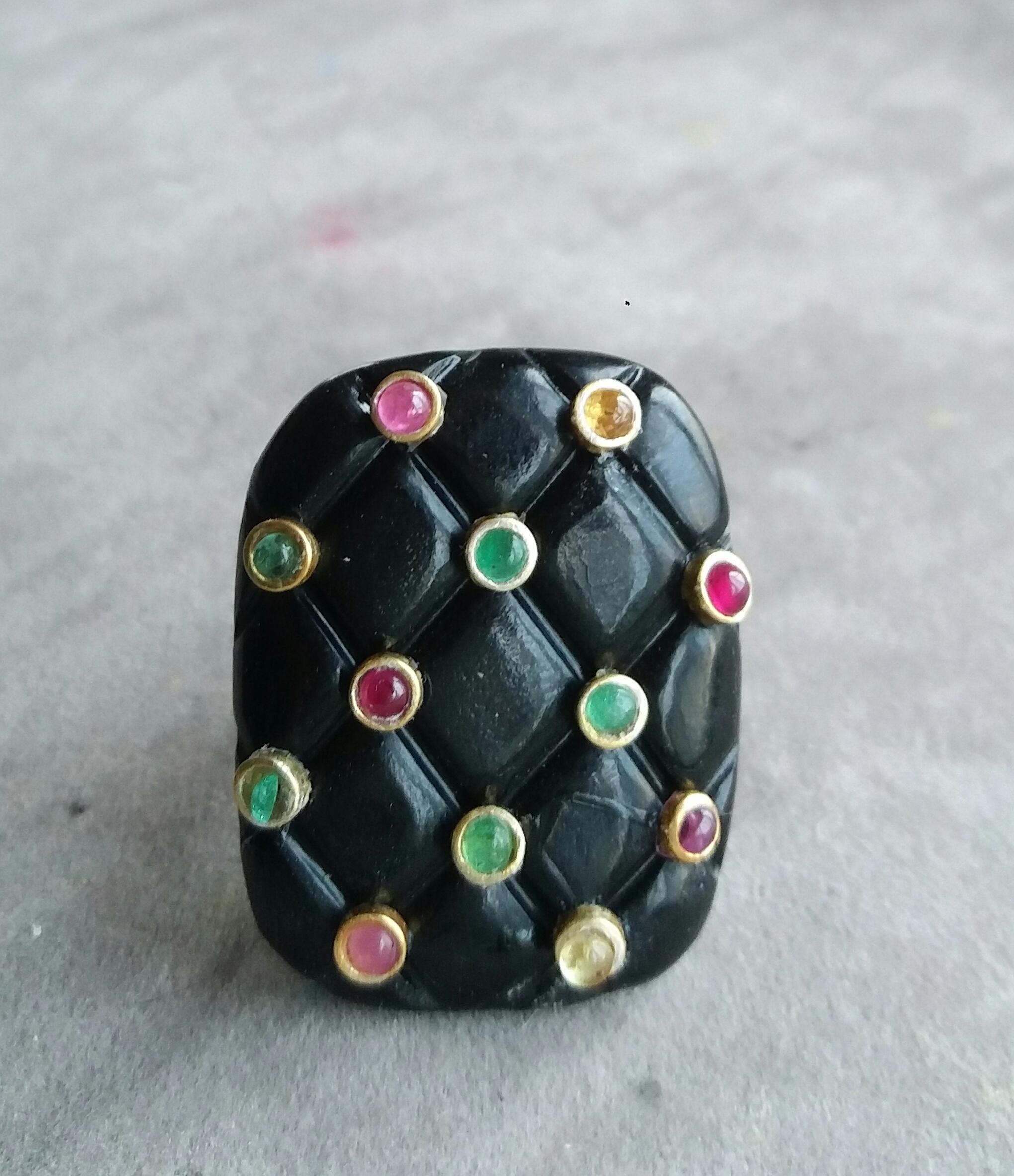 Extremely Stylish and Unique Ring composed by a Natural Black Onyx Cushion Shape measuring 27 x 34 mm and weighing 80 Carats, decorated with 12 small round Rubies, Emeralds and Yellow Sapphires set in 14K yellow small gold bezels.

In 1978 our
