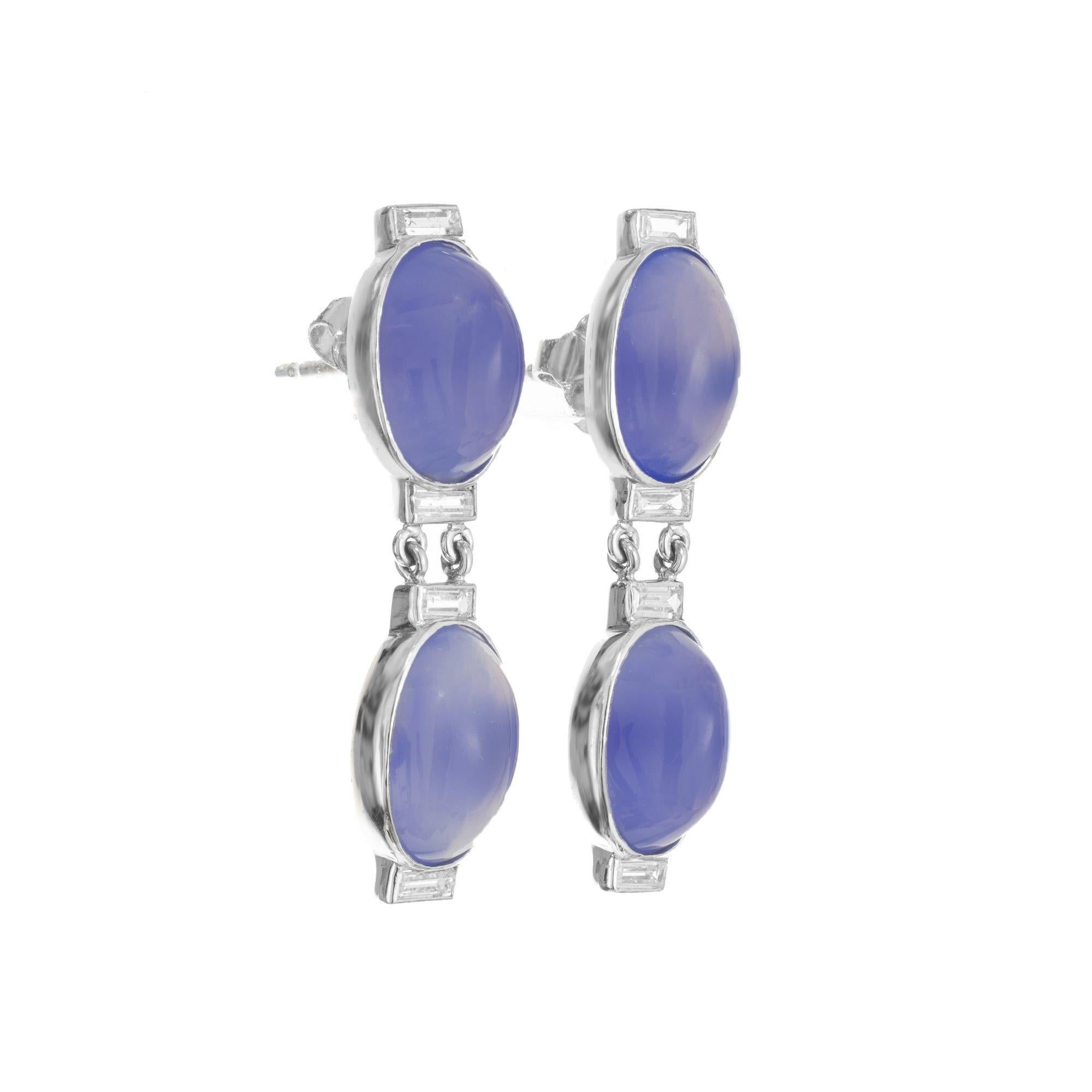 Artisanal Late Art Deco Chalcedony and diamond dangle earrings. Four natural oval cabochon light to medium blue Chalcedony set in platinum bezel frames. Each section is spaced by baguette diamonds. The Chalcedony have unique color zoning on each