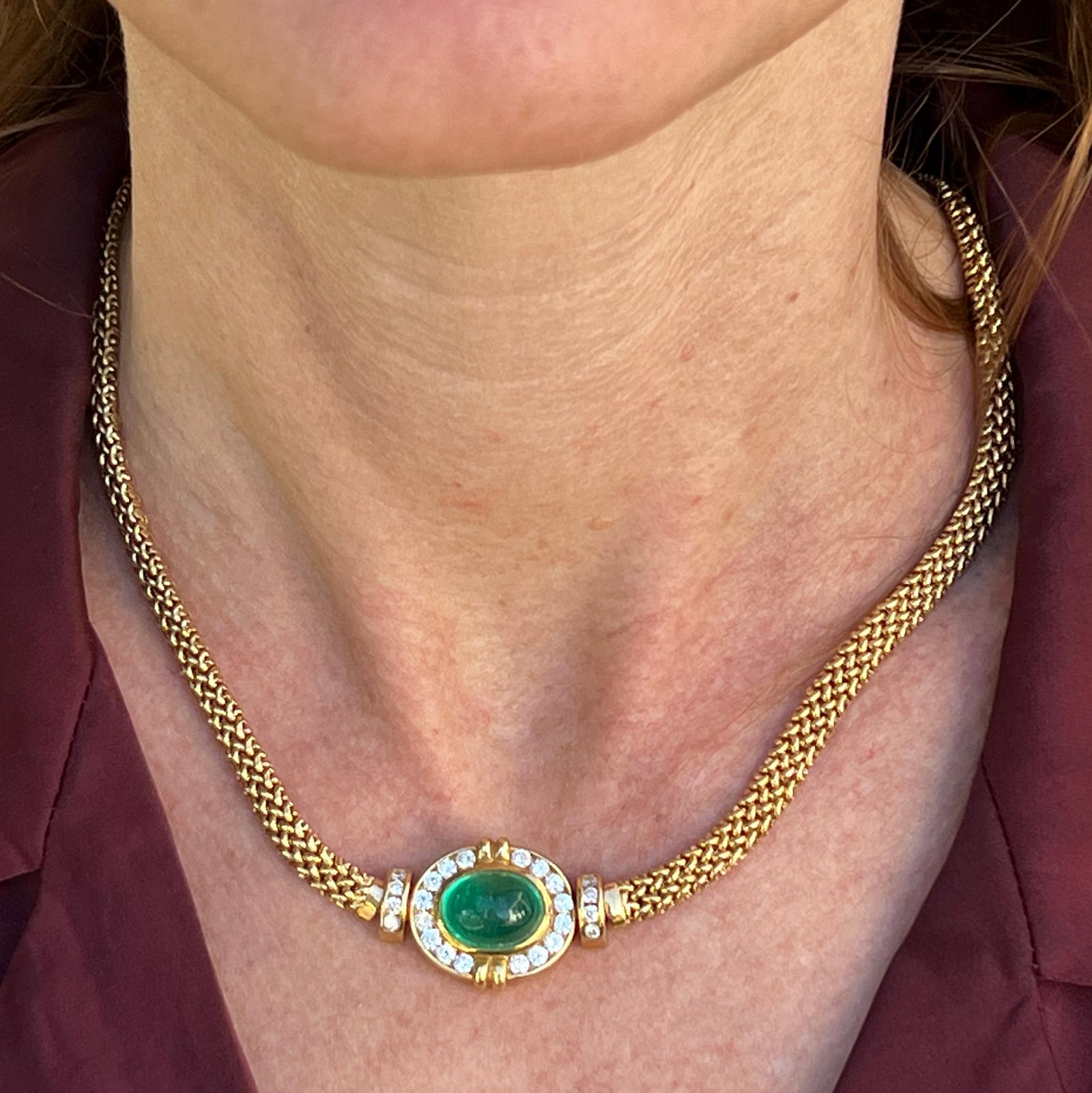 Beautiful emerald and diamond pendant necklace crafted in 18 karat yellow gold. The  15 x 20mm pendant features an approximately 8.00 carat cabochon oval emerald gemstone surrounded by 24 round brilliant cut diamonds weighing approximately 1.32