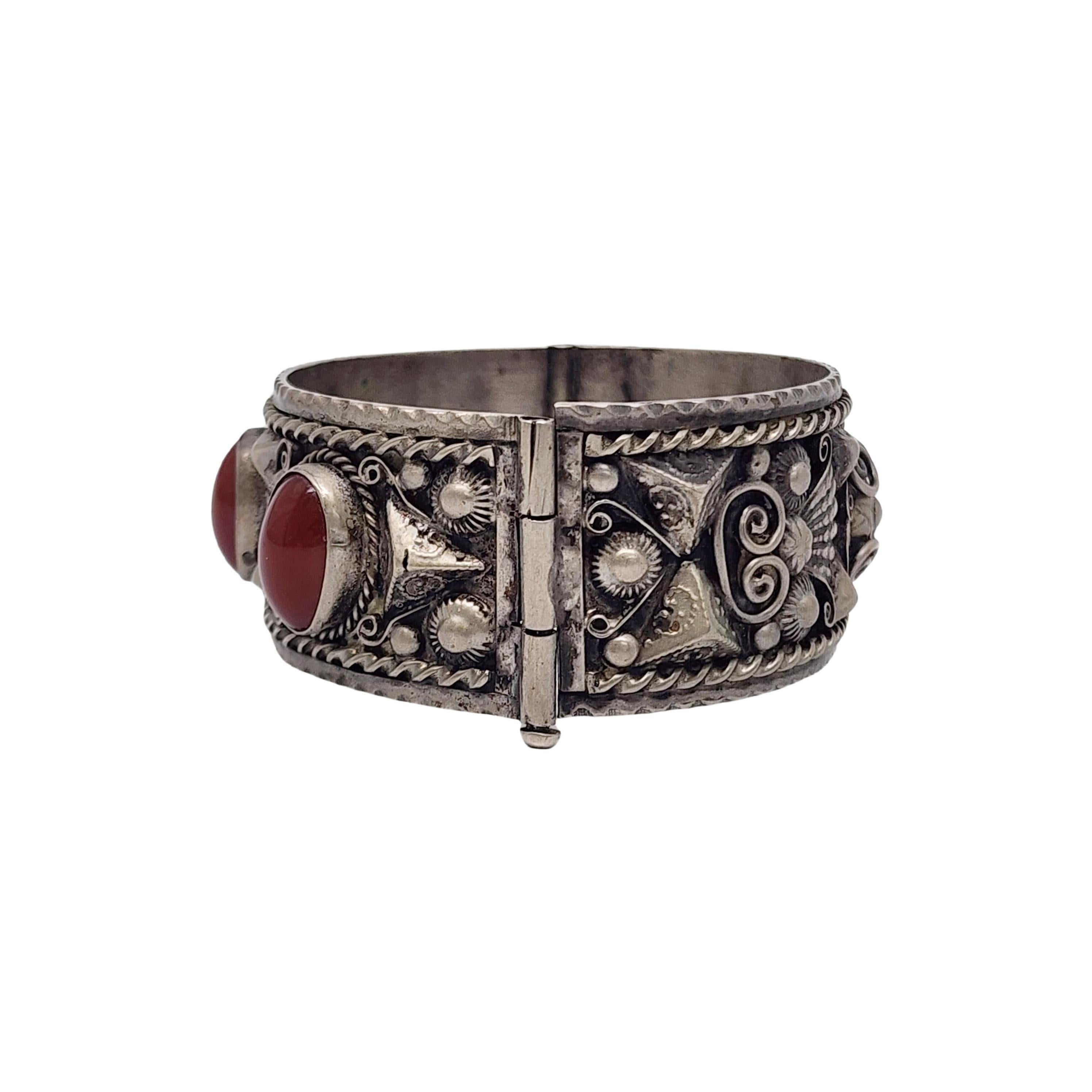 Bracciale a bracciale con cerniera Barber marocchino in argento 800 e corniola.

Bracciale bangle largo e incernierato con disegni di Barber marocchini e 3 pietre ovali di corniola incastonate in intricati disegni. Un perno viene estratto per aprire