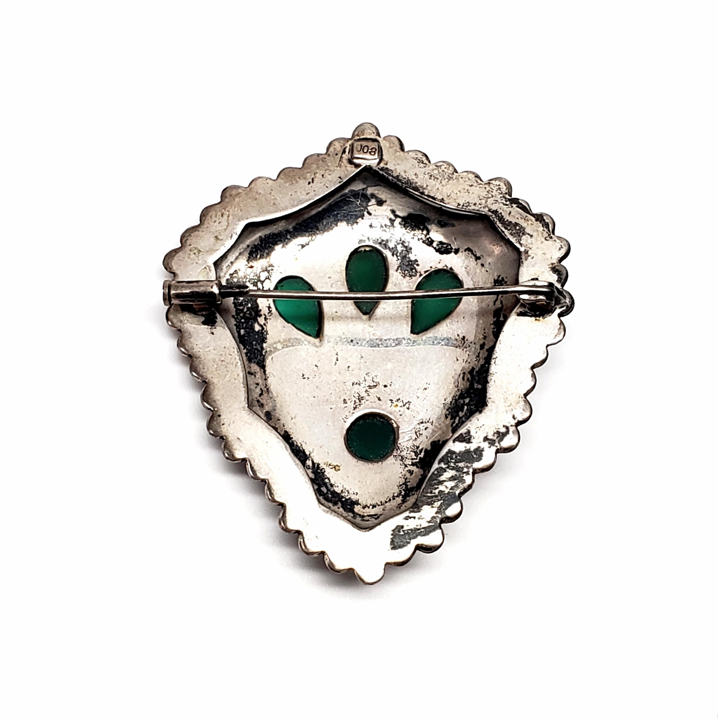 Vintage 800 silver and chrysoprase pin/brooch.

Large and ornately adorned pin with filigree and ball accents around 3 teardrop and 1 round chrysoprase cabochons.

Pin measures approx 2 1/4