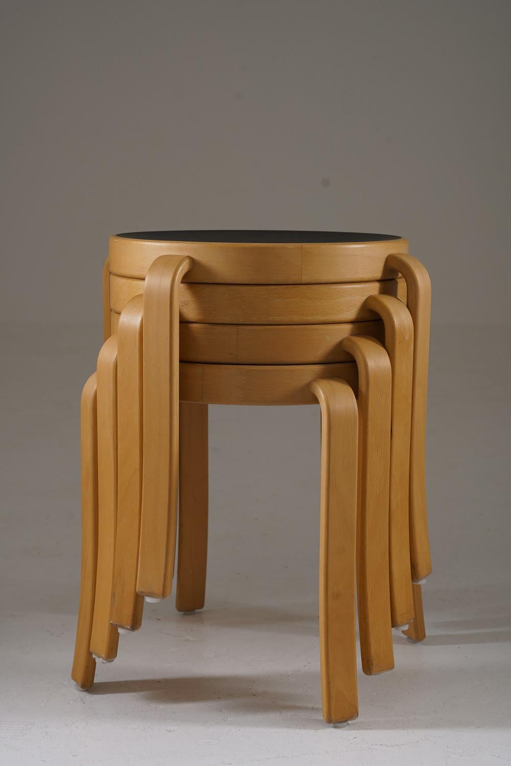 These are 8000 Series Stools designed by Rud Thygesen and Johnny Sørensen, showcasing a minimalist Scandinavian aesthetic. Made from beech wood, they feature elegantly bent legs that highlight precision craftsmanship, combined with circular black
