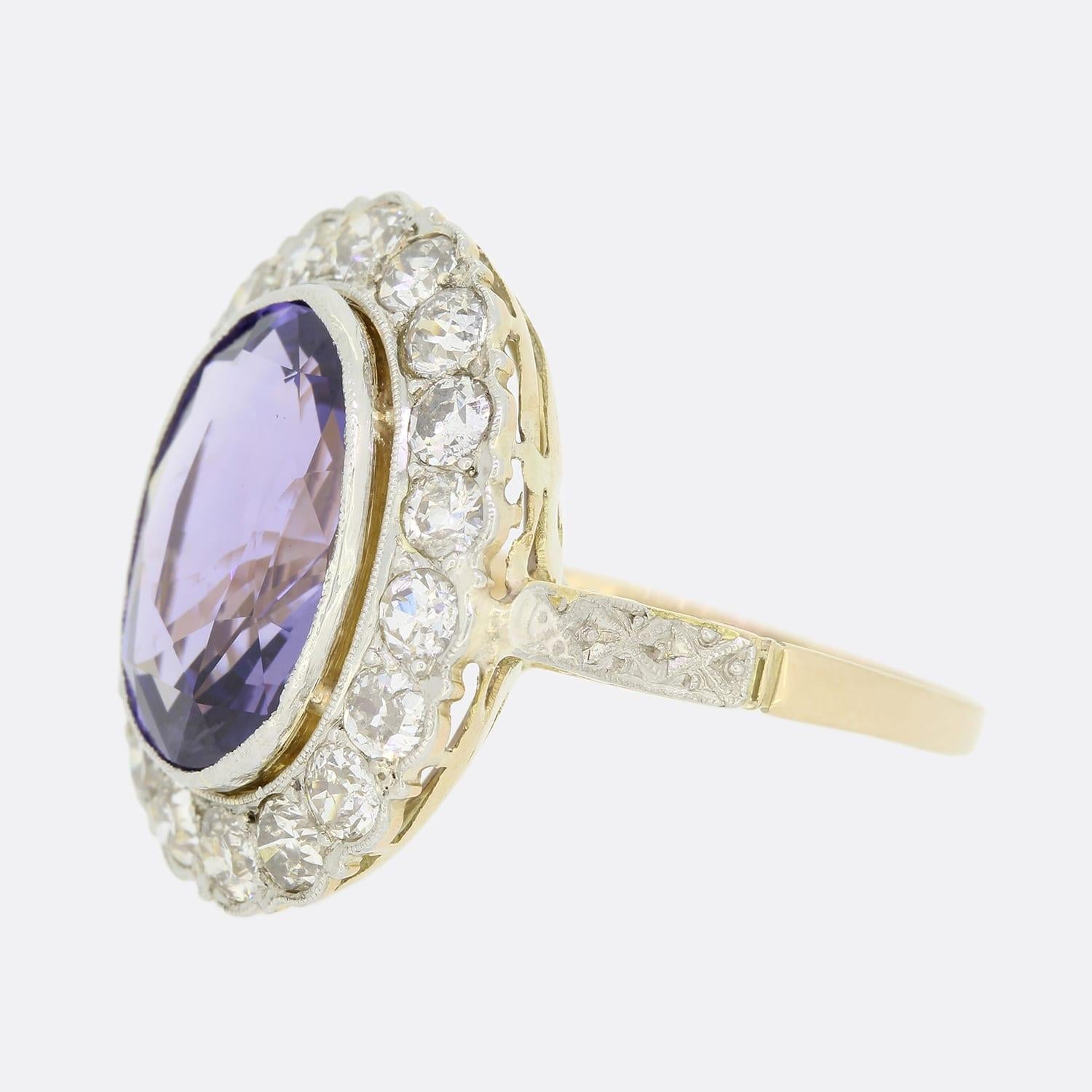 Dies ist ein Vintage 18ct Gelbgold Saphir und Diamant-Cluster-Ring. Der zentrale oval geschliffene Saphir ist in einer Rubraffassung gefasst und wird von 18 Diamanten im Altschliff umgeben. Der zentrale Edelstein ist ein natürlicher, unerhitzter