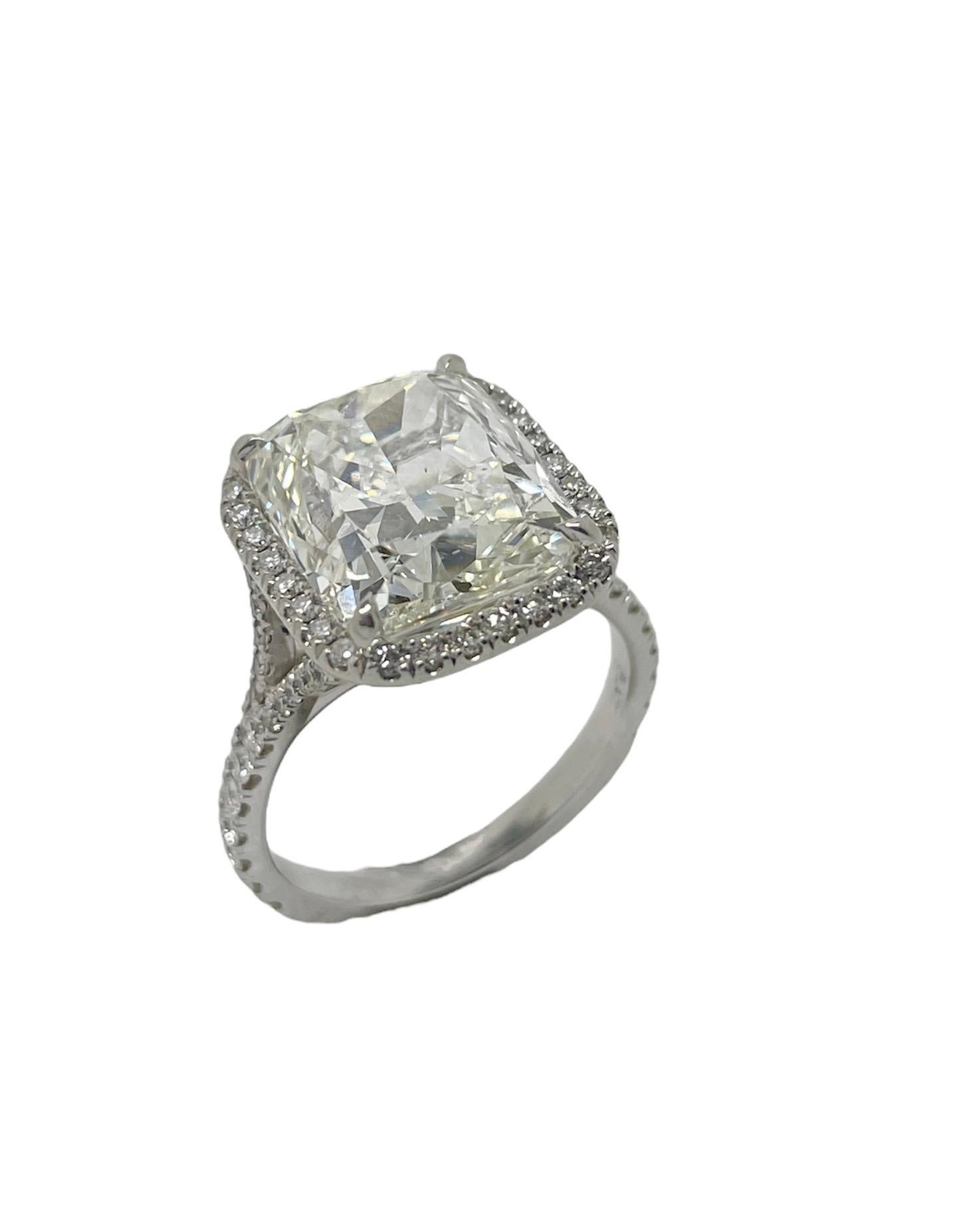 This absolutely stunning ring features a 8.02 carat cushion modified brilliant cut diamond with J color and SI1 clarity, surrounded by 68 round brilliant cut diamonds weighing approximately 1.16 carats total. Mounted in platinum and skillfully