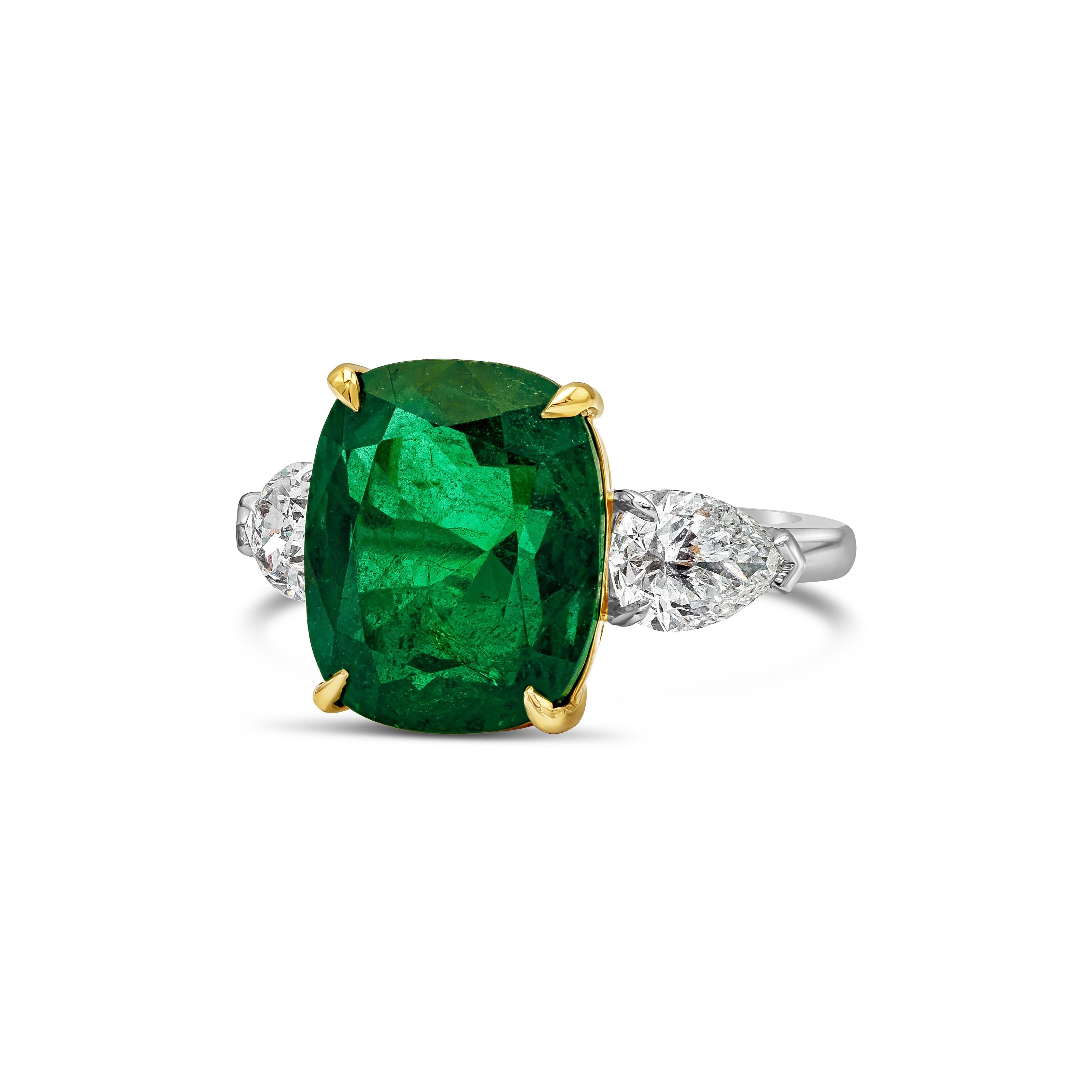 This beautiful and elegant engagement ring showcasing a color-rich cushion cut green emerald center stone weighing 8.02 carats, flanked by two GIA certified pear shape diamonds weighing 1.49 carats total, E color and SI2 in clarity. Set in a