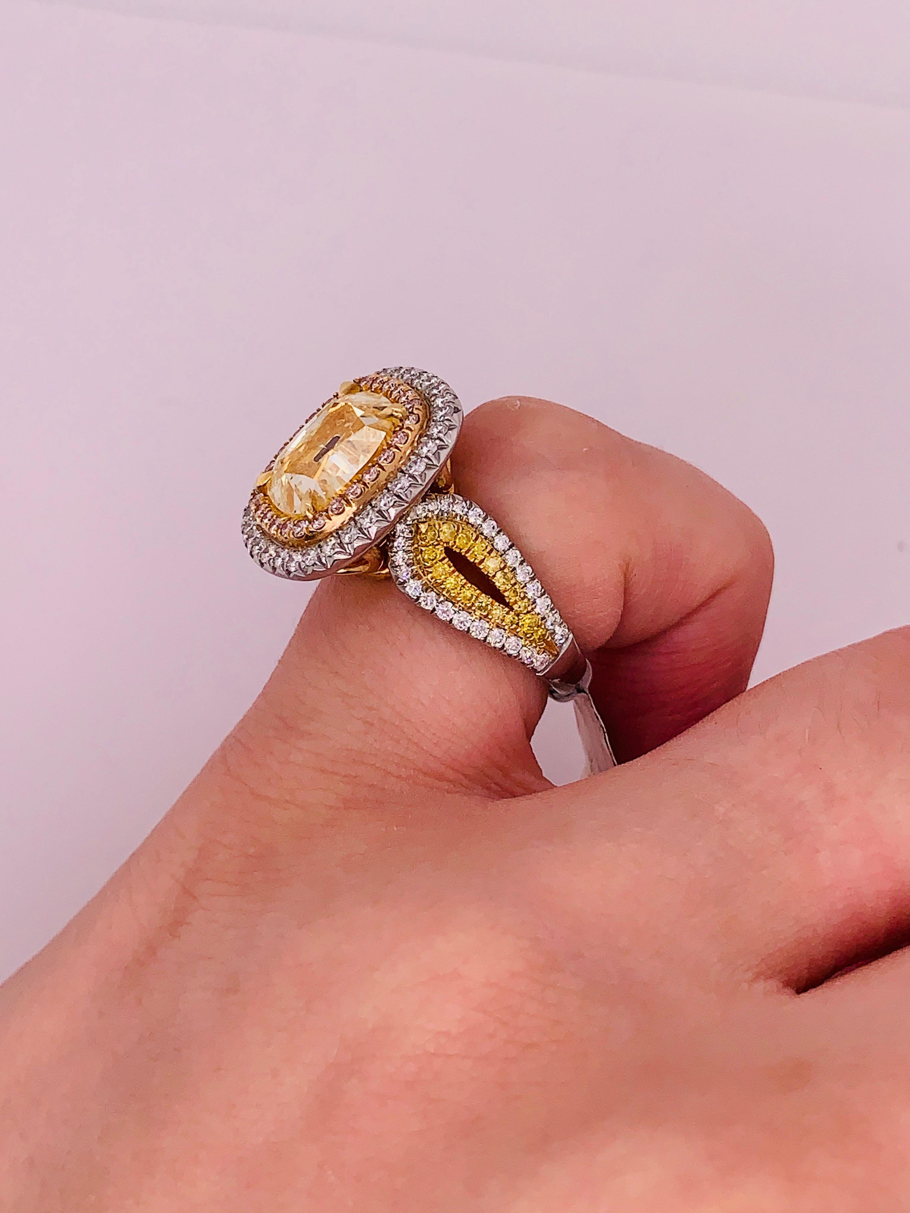 This one of a kind diamond ring, designed by Diana M. Jewels combines three natural colored diamonds, Fancy Pink, Fancy Yellow and White diamonds. 
The center stone is 5.02 Carats Fancy Yellow Cushion Cut Diamond, SI1 in Clarity, accompanied by  EGL