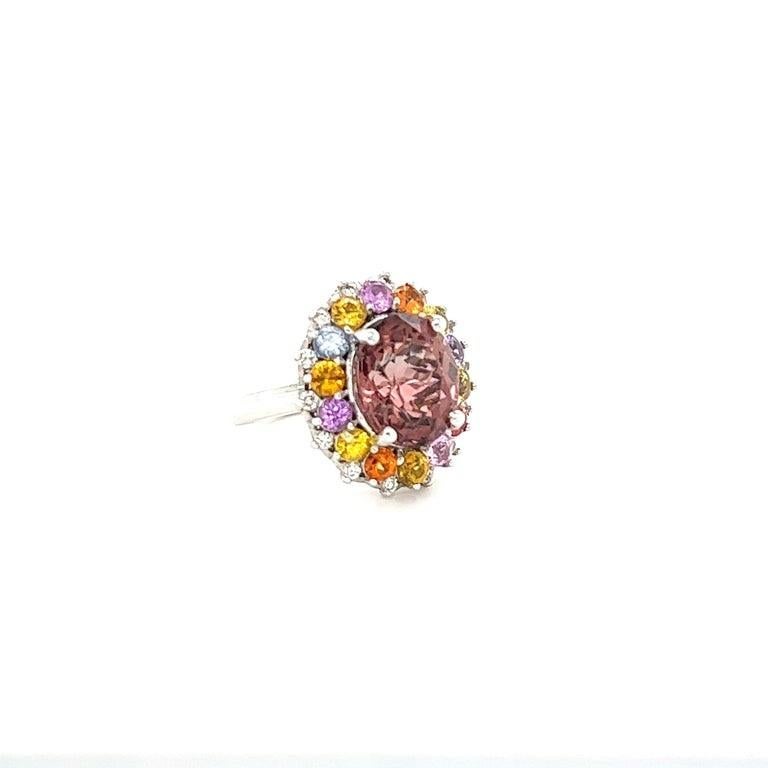 8.04 Carat Tourmaline Sapphire Diamond White Gold Cocktail Ring

This ring has a 5.83 carat Oval Cut Tourmaline that measures at 12 mm x 10 mm and is elegantly surrounded by 14 Round Cut Multi-Colored Sapphires that weigh 1.96 carats and further