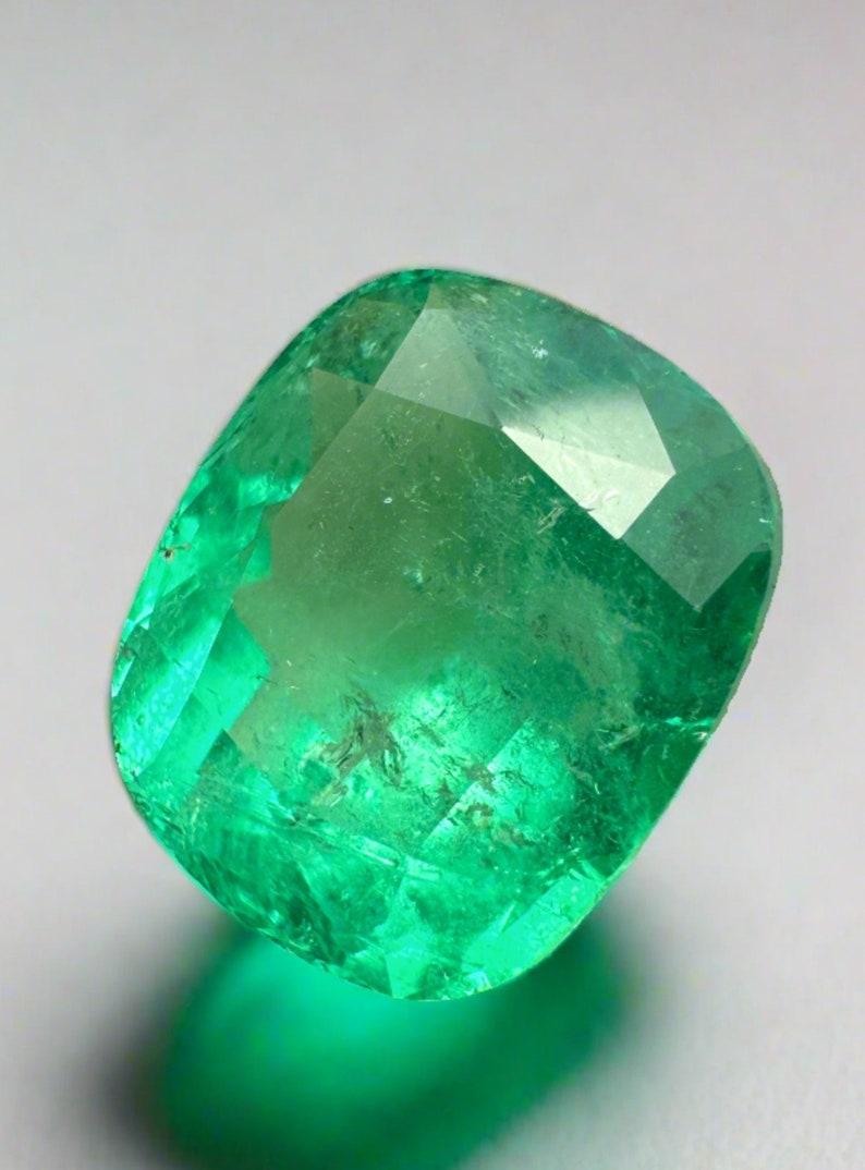 Stone: Emerald
Weight: 8.04-carats
Shape: Cushion Cut
Clarity: Transparent
Luster: Very Good
Color: Yellowish Green
Measurements: 13.17mm x 11.09mm x 8.21mm
Geographic Origin: Colombia
Treatment: Natural, Oiling

Comments: Due to their growth