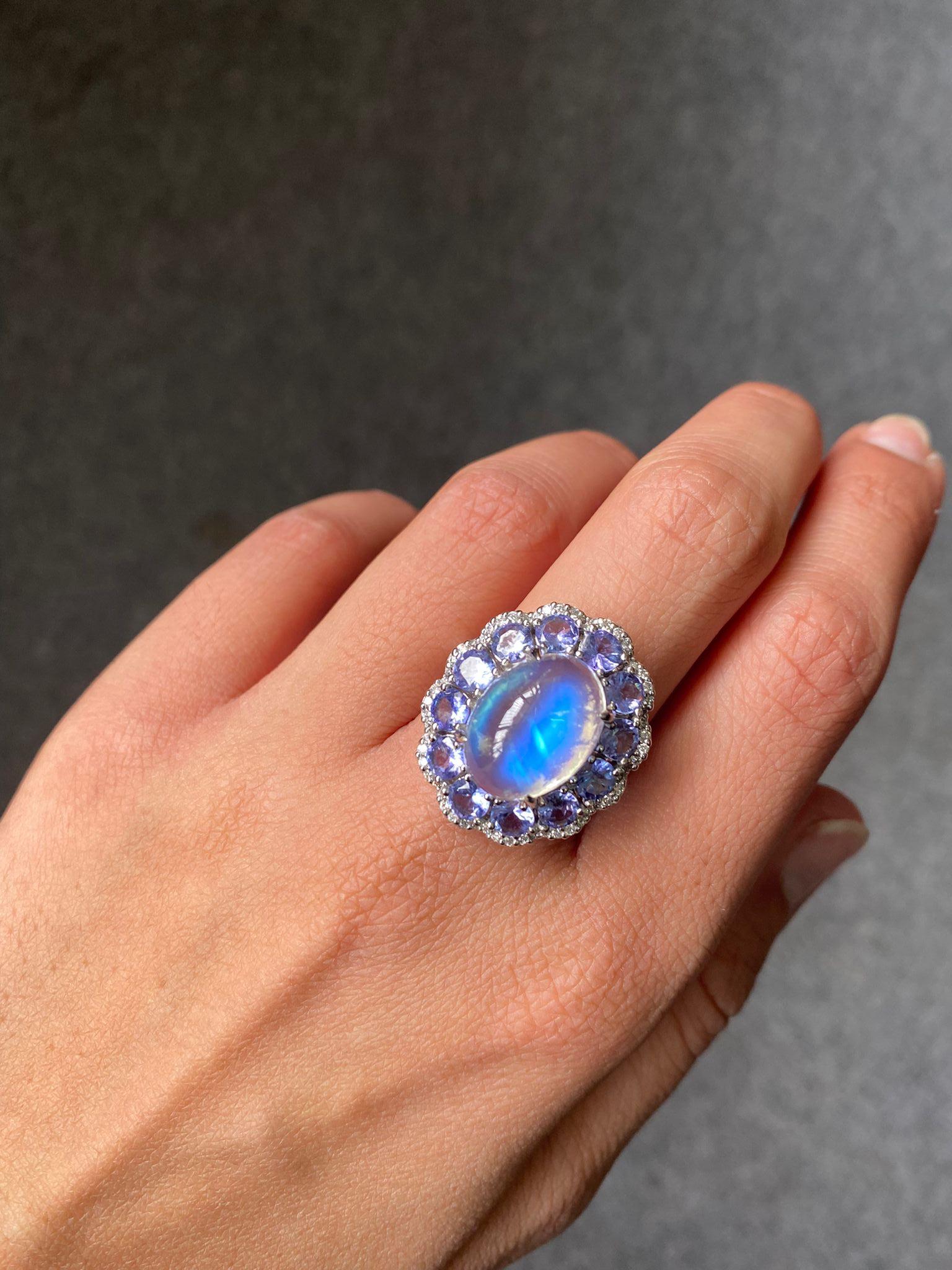 A beautiful 8.07 carat Moonstone cocktail ring with 12 pieces of 2.82 carat Blue Sapphire rose cut rounds surrounding it with 0.36 carat White Diamonds, all set in solid 18K White Gold. Currently  sized at US7, can be resized. The combination of