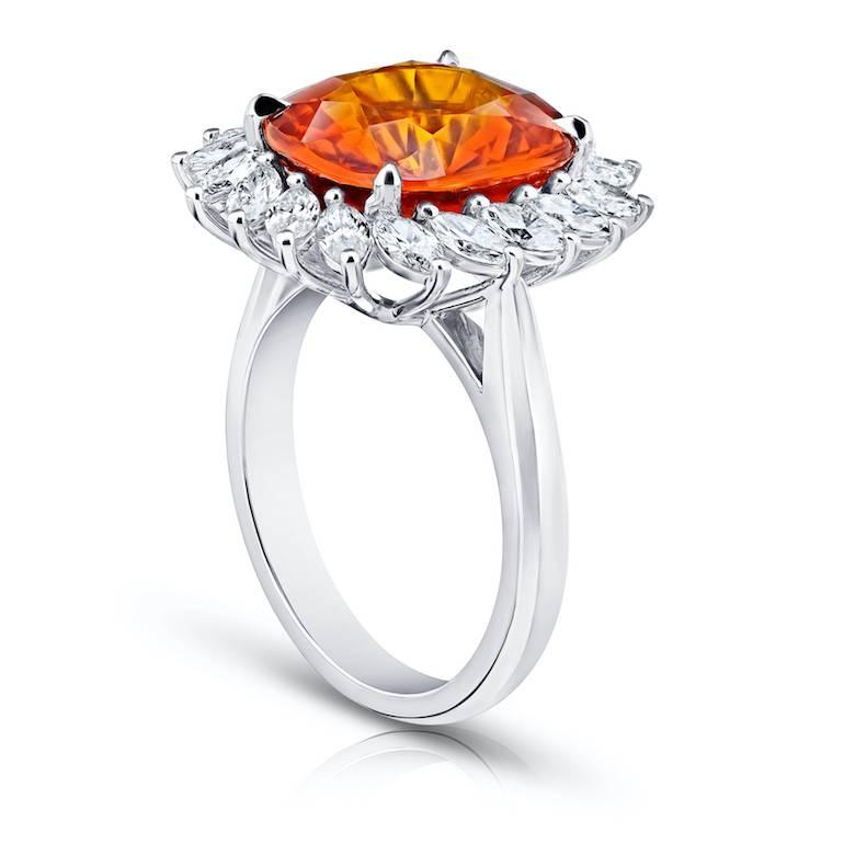 8.08 carat cushion cut orange sapphire with eighteen marquise shape diamonds 1.33 carats set in platinum ring.
