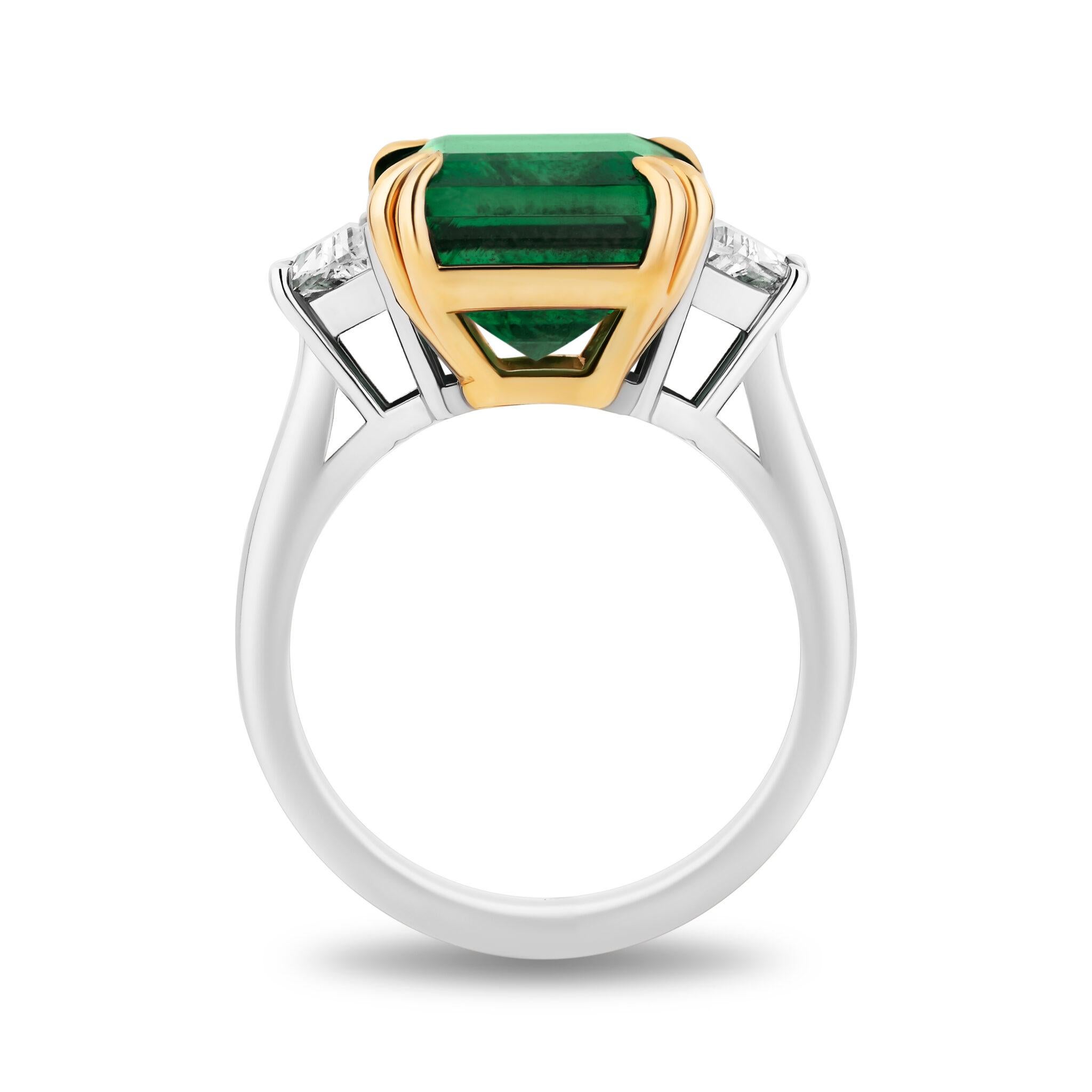 Indulge in the splendor of this exquisite emerald-cut ring, which showcases a remarkable total weight of 8.08 carats. The design is accentuated by elegant step-cut trapezoid diamond side stones that add a touch of brilliance and refinement to the