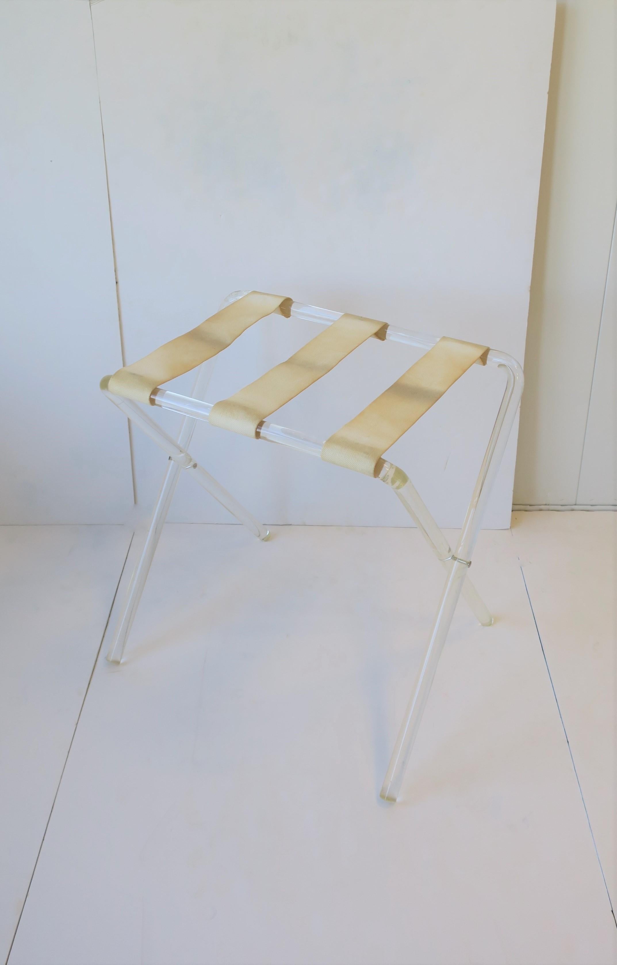'70s Modern Lucite folding luggage rack or stand with canvas straps, circa 1970s-1980s, late-20th century. Two (2) available, each sold separately as per listing. 

Measurements: 15.5