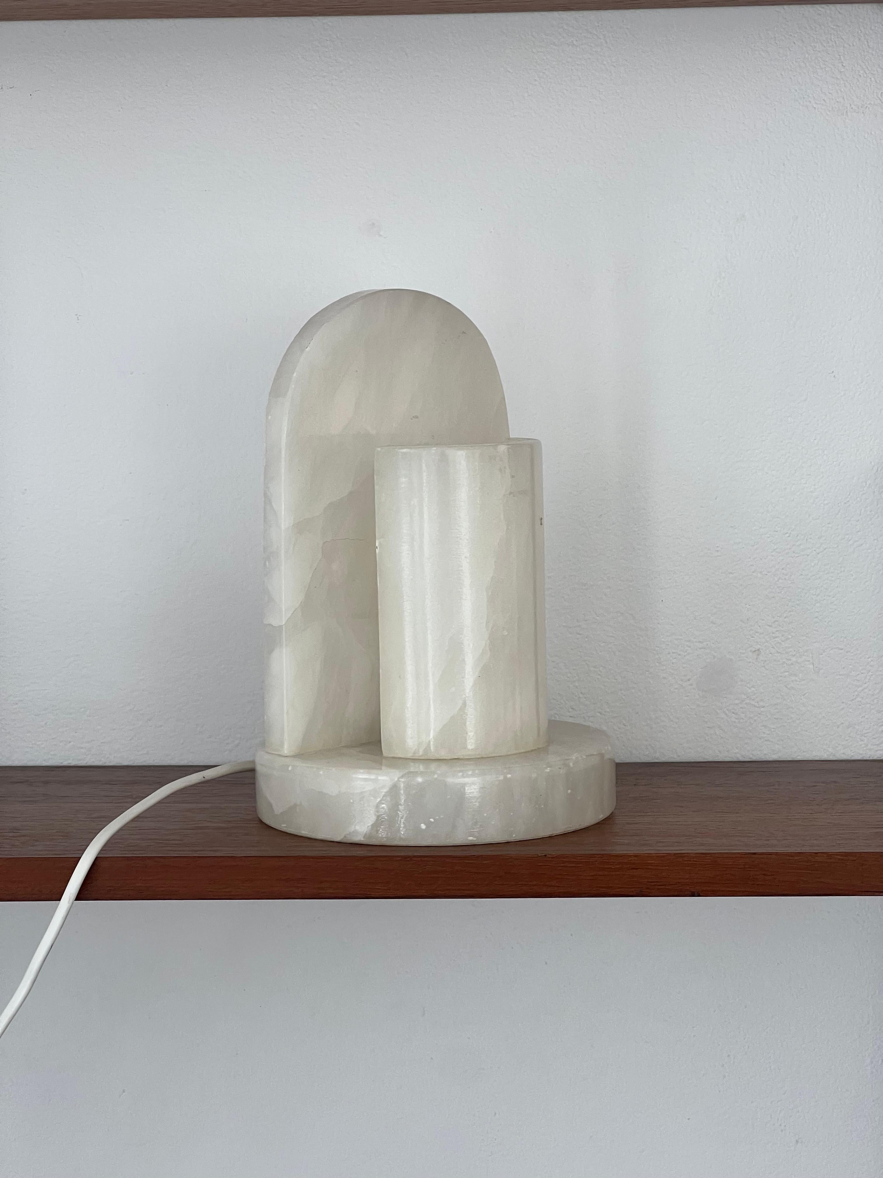 Alabaster lamp from the 1980s. Its designer is unknown. Its structure is entirely in alabaster with a semi-circle and a cylinder on its upper part framing the bulb. 
In very good condition, due to age and use.