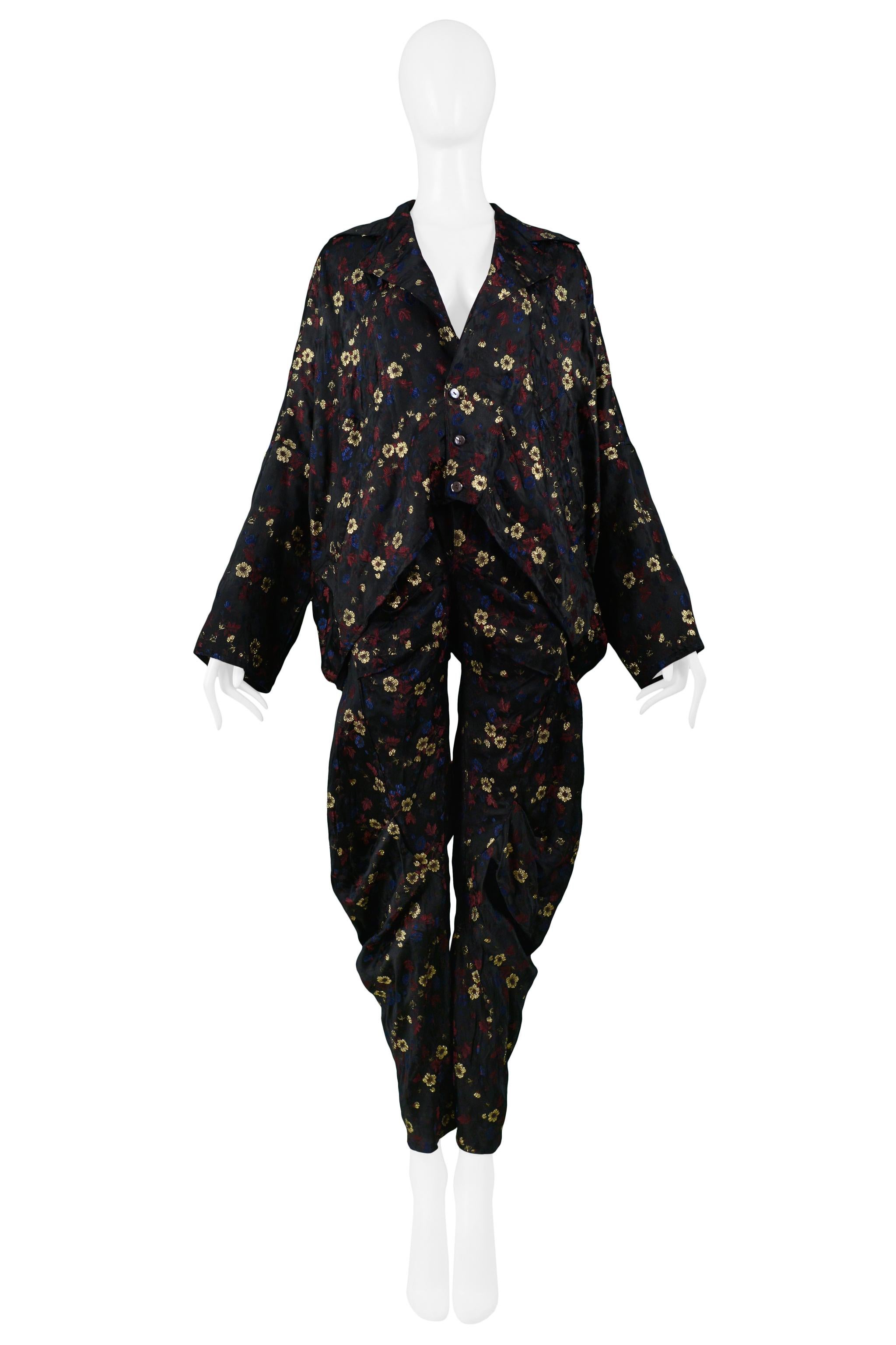 Resurrection Vintage is excited to offer a vintage Rachel Auburn jacket and pants ensemble featuring a metallic floral jacquard textile, a button-front jacket with an overlapping back with an exposed cutout. The pants feature all-over draping, side