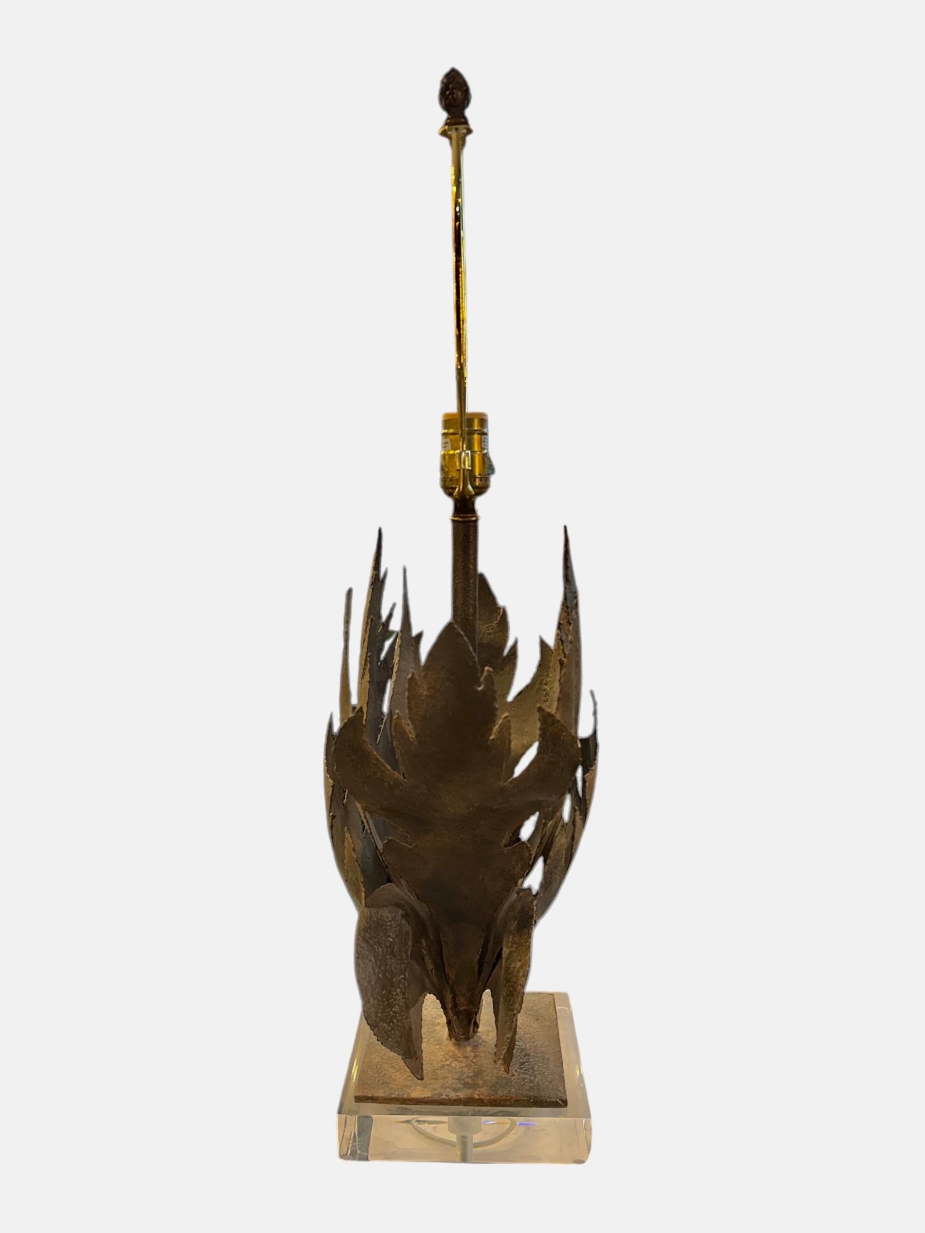 Cette lampe Brutalist Iron Leaf avec base en Lucite allie harmonieusement la force industrielle à l'élégance artistique. La base sculpturale en fer et Lucite présente des motifs de feuilles audacieux et texturés, capturant la beauté brute et