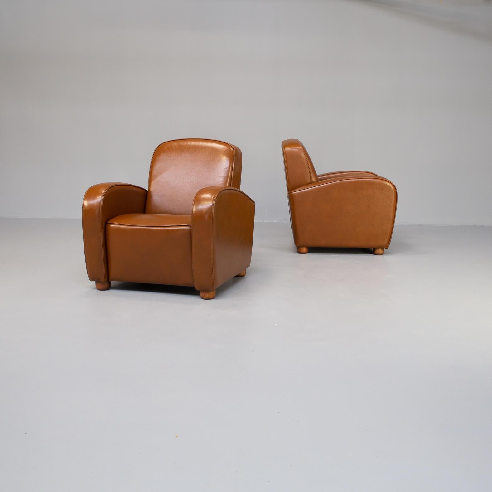 One set of two beautiful lounge fauteuils in cognac leather by the Italian IDP Industria divani e Poltrone. The building quality of these chairs are very high end, good to be seen on the seating cushion with the almost smiling way the chairs looks