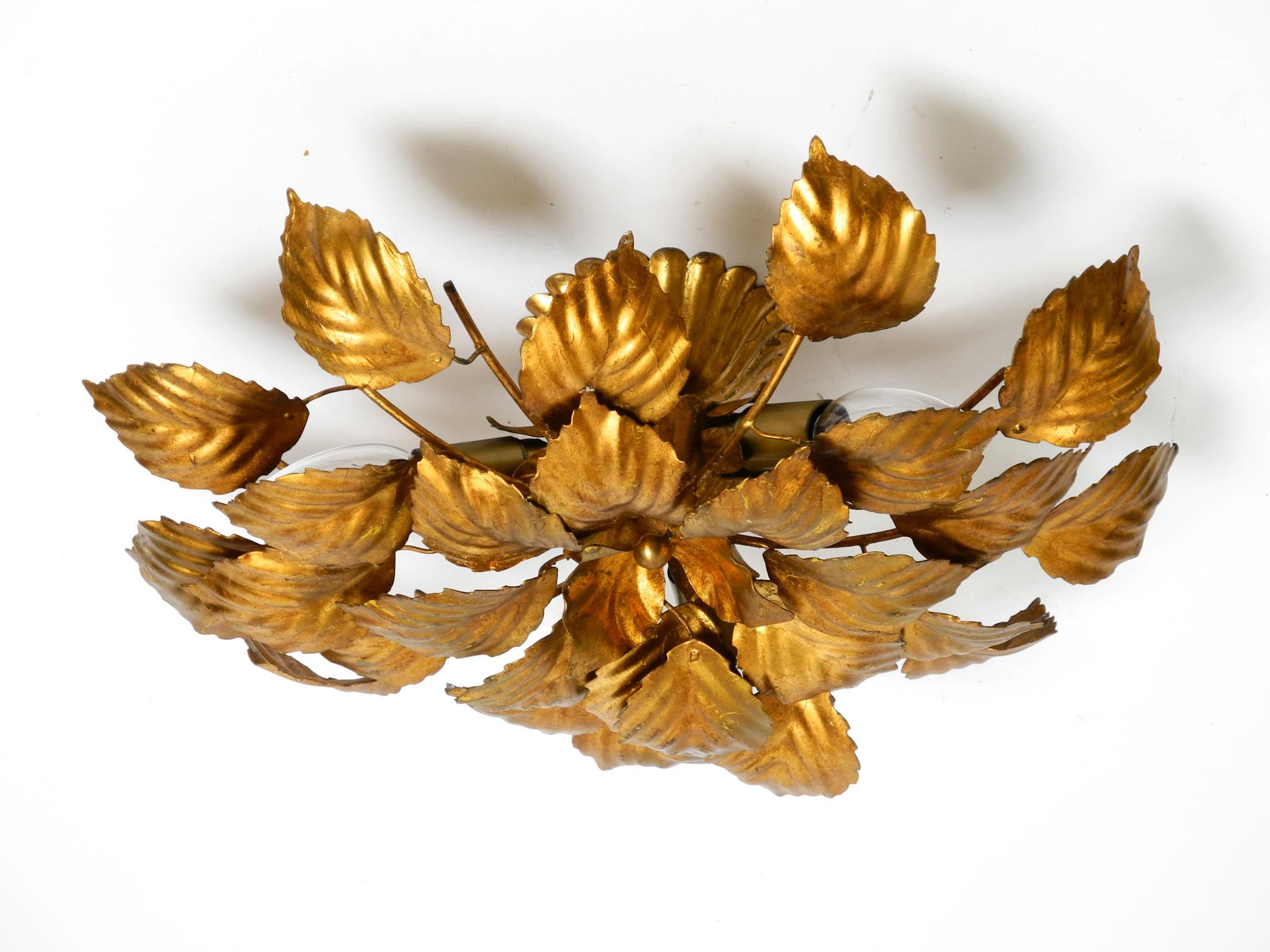 Schöne vergoldete florale Hollywood-Regency-Deckenlampe aus den 1980er Jahren mit großen Blättern.
Sehr elegantes Design mit realistischen großen Blättern aus vergoldetem Metall.
Voll funktionsfähig mit drei E14-Fassungen. Geeignet für alle